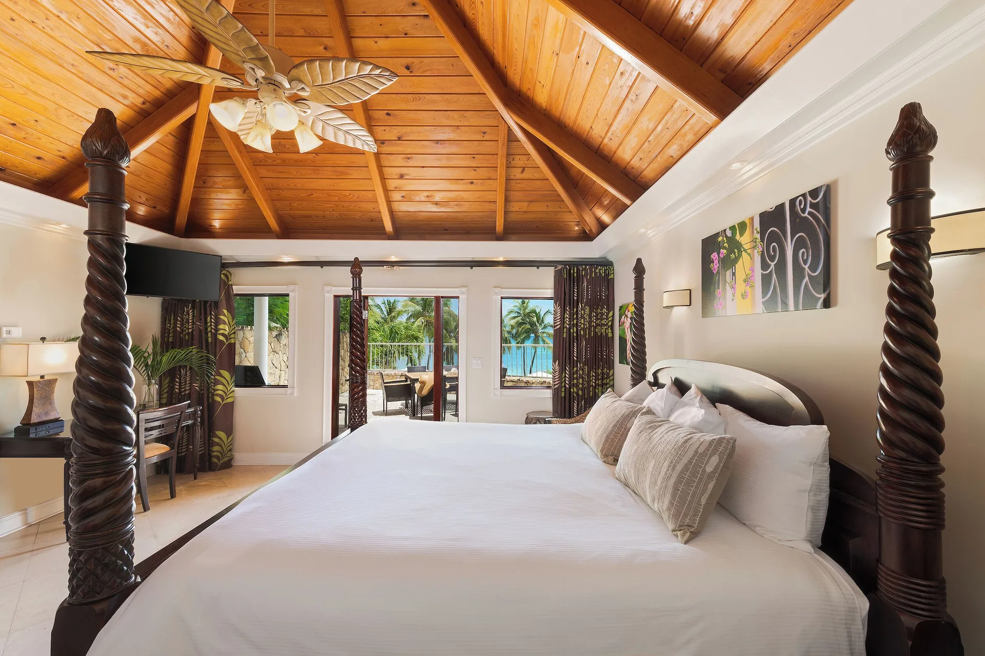 Ficus Suite king bed and balcony view at The Buccaneer Beach & Golf Resort.