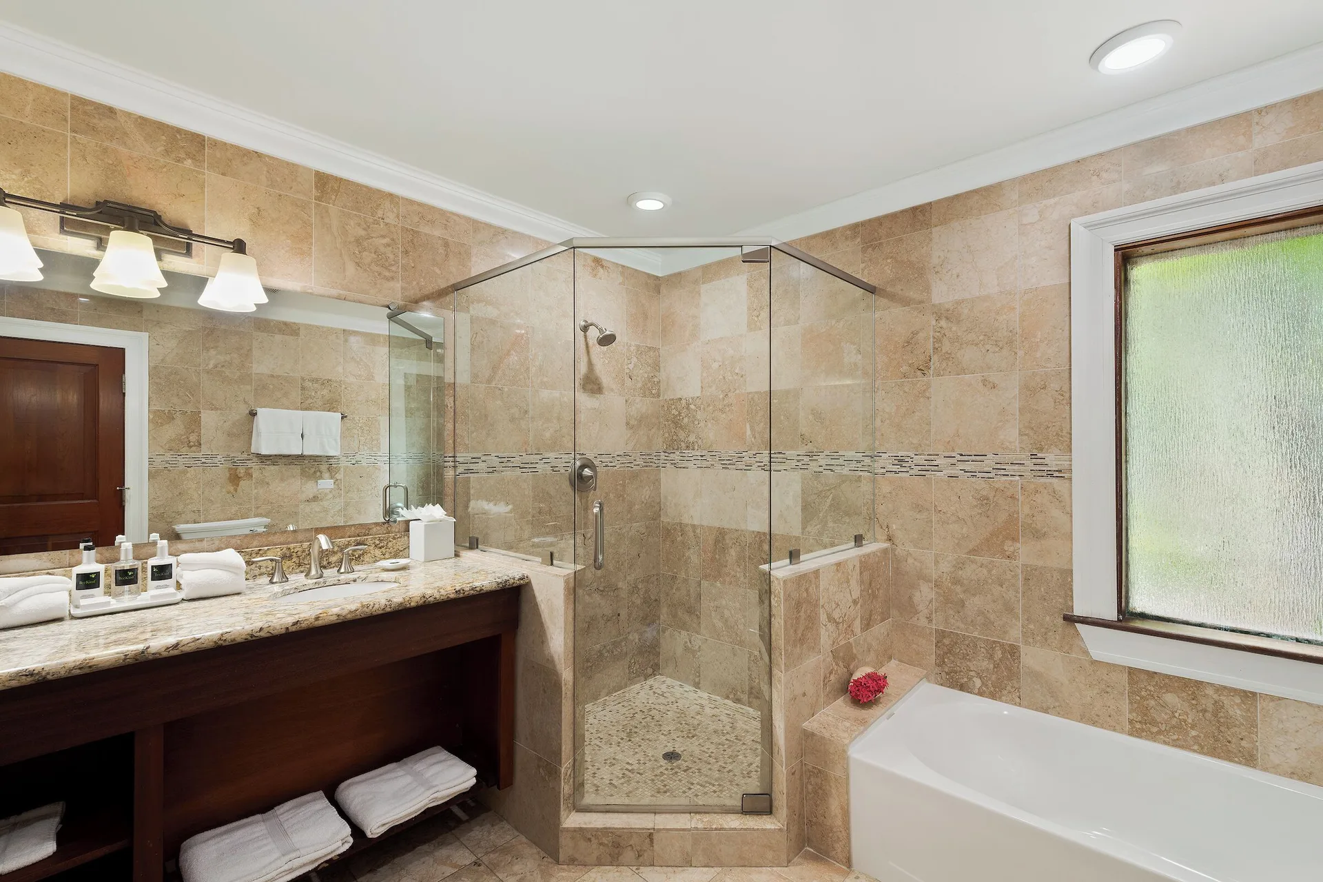Frigate Suite bathroom with glass shower and soaking tub at The Buccaneer Beach & Golf Resort.