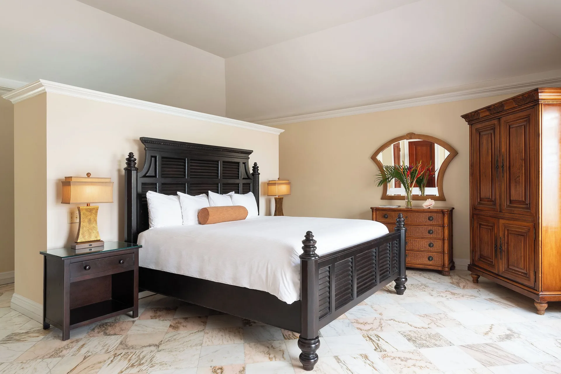 Frigate Suite king bed with wood armoire and dresser at The Buccaneer Beach & Golf Resort.