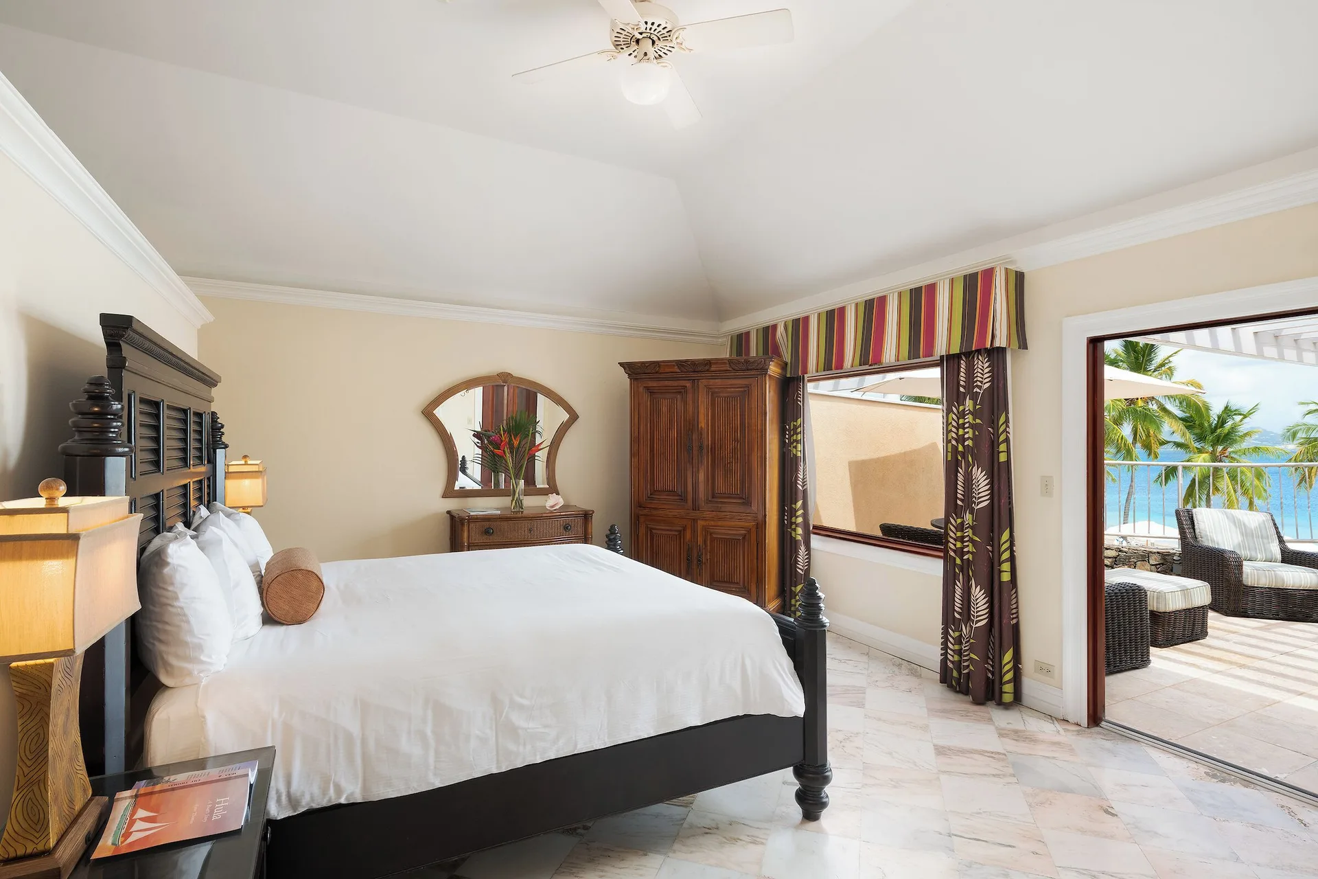 Frigate Suite king bedroom with terrace and ocean glimpse at The Buccaneer Beach & Golf Resort.