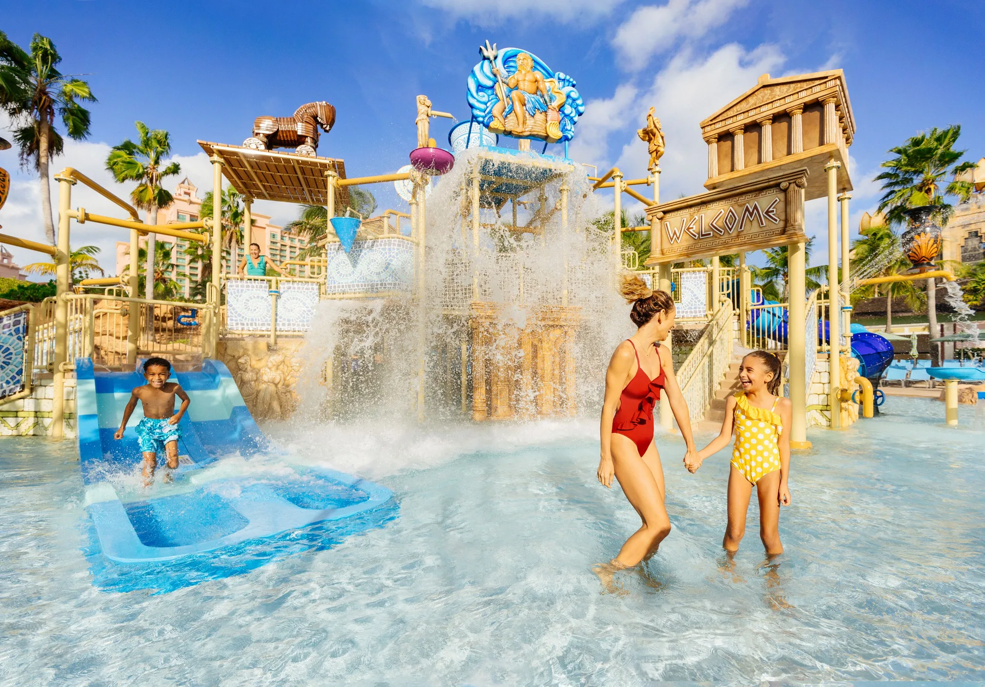 Children play in a splash area with slides and water buckets at The Coral at Atlantis.