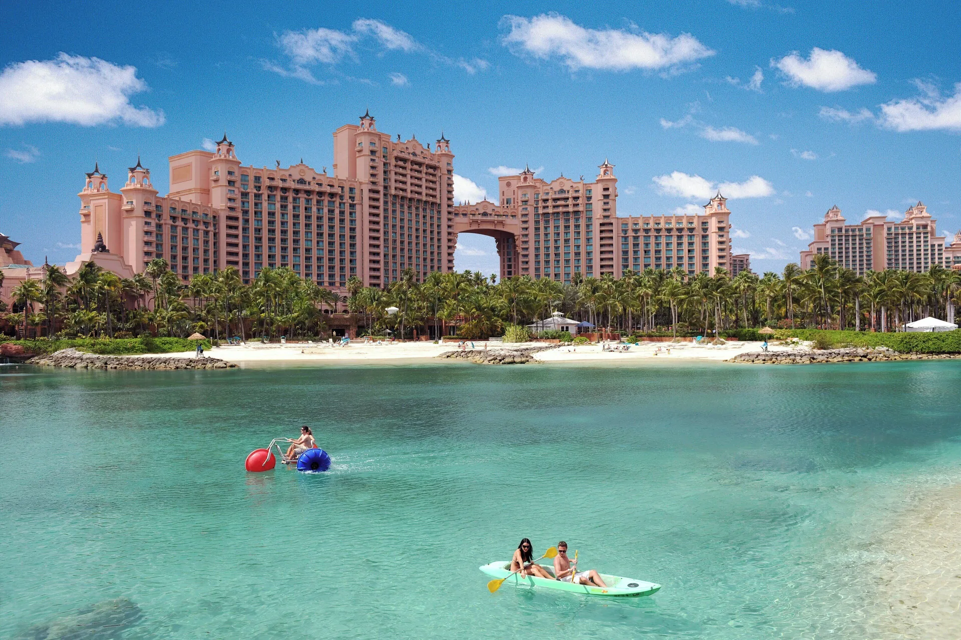 Turquoise lagoon with paddleboats and resort towers at The Coral at Atlantis.