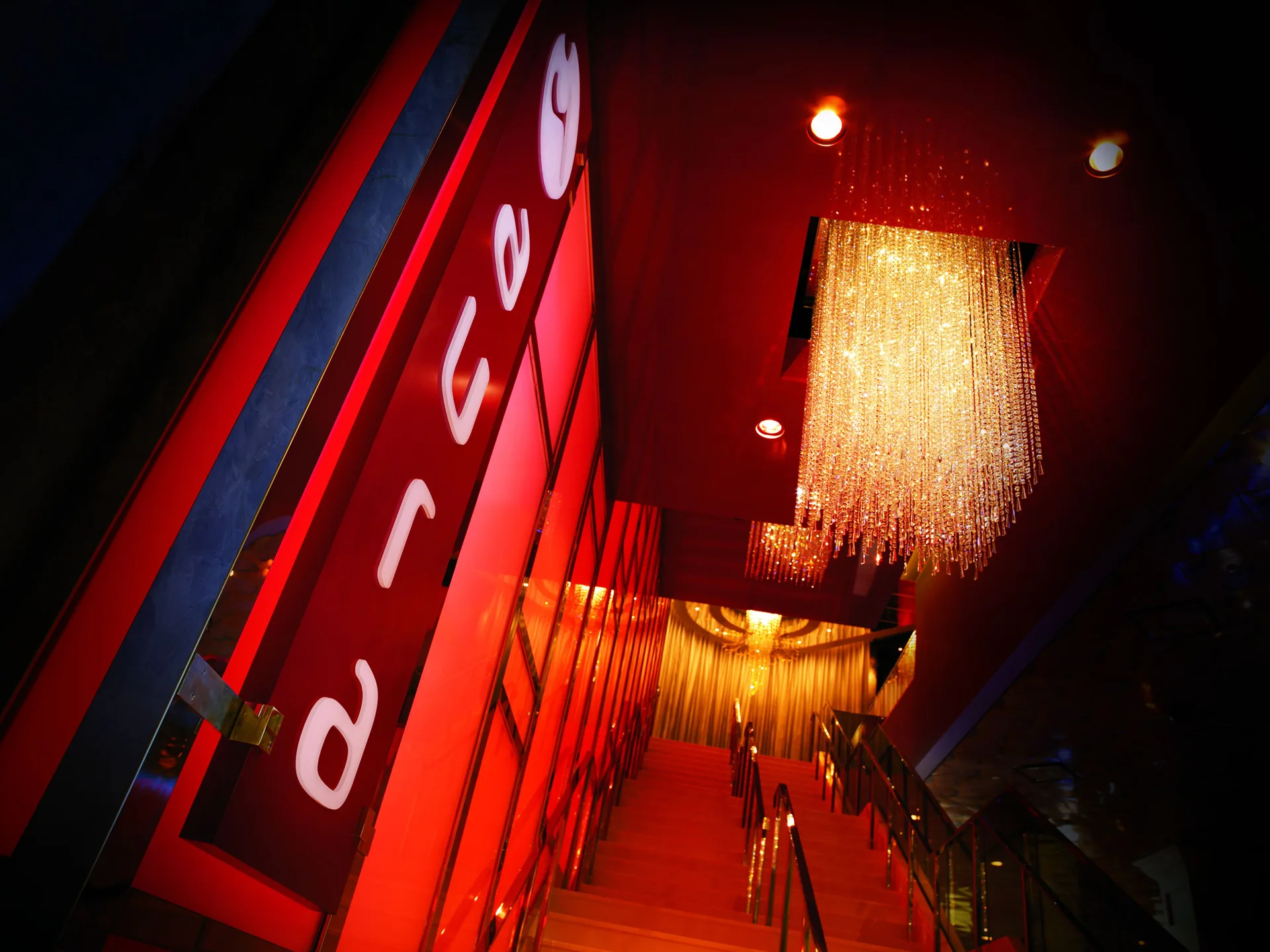 Red-lit restaurant stairway with crystal chandeliers at The Coral at Atlantis.