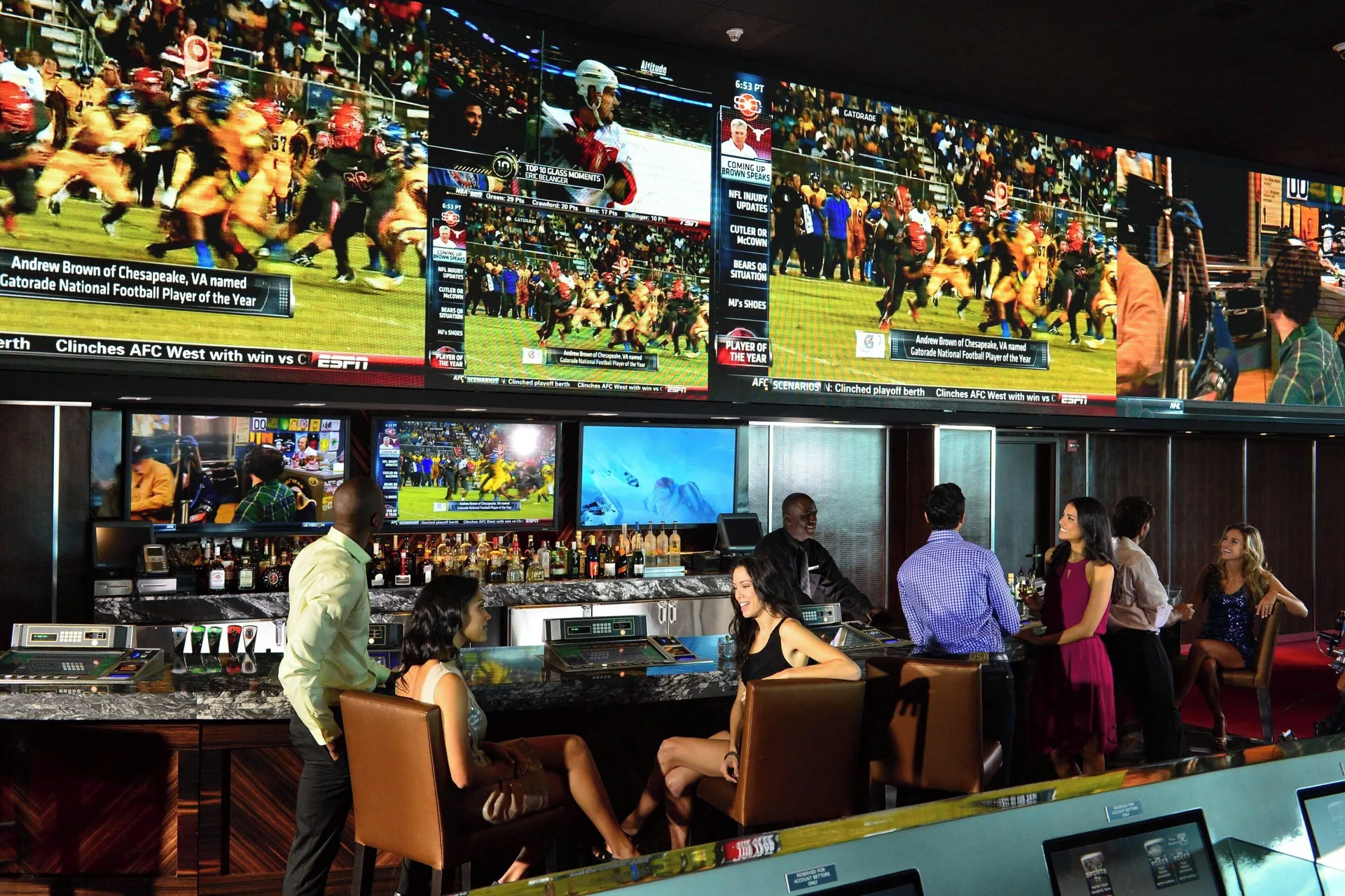 Sports bar with large screens and seated guests at The Coral at Atlantis.