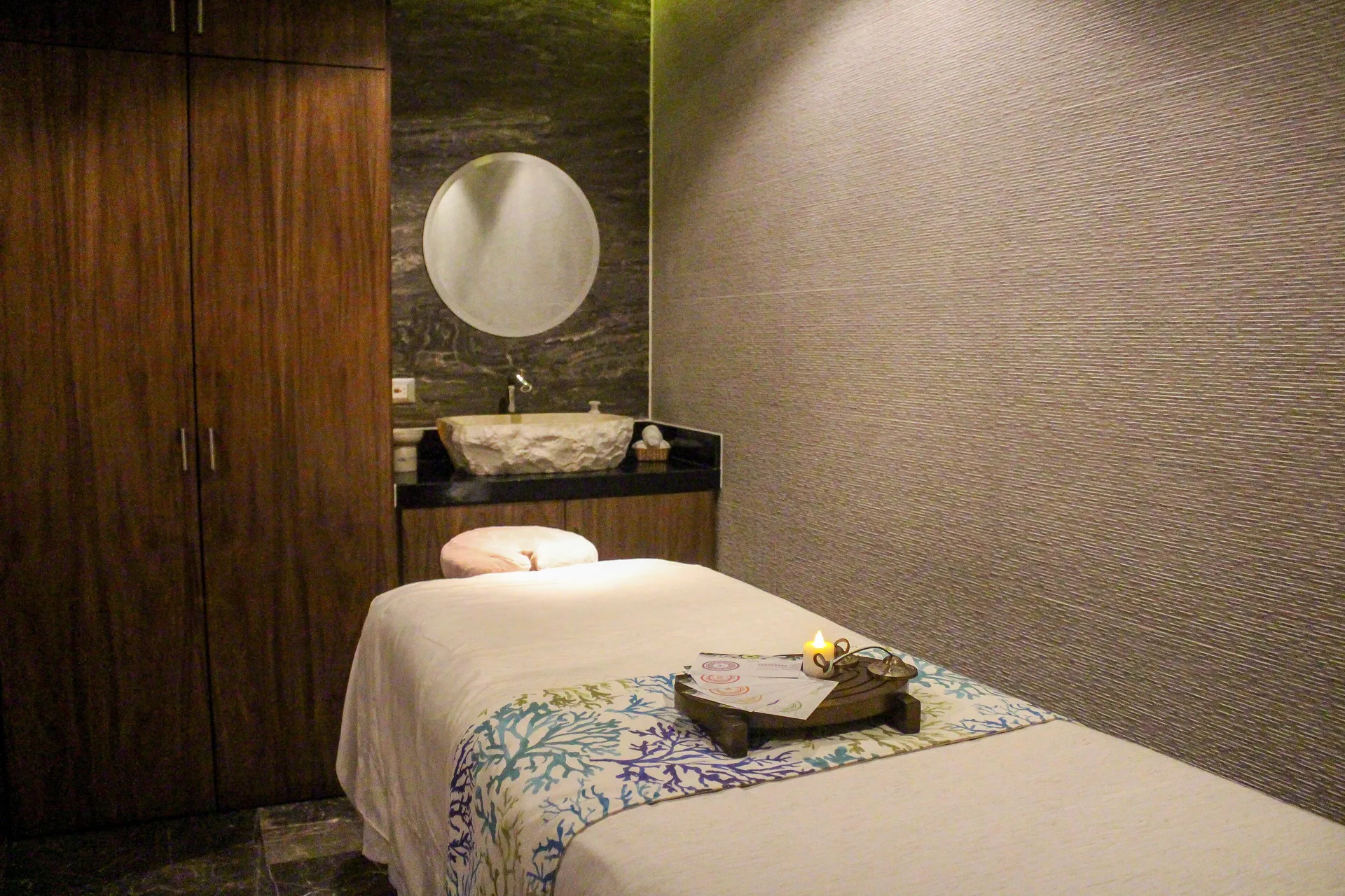 Spa treatment room with massage table and vanity at The Fives Oceanfront Riviera Maya.