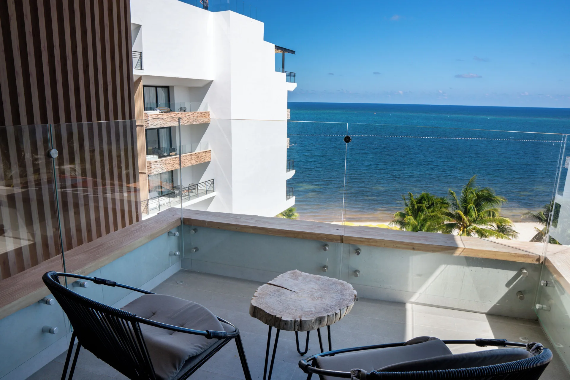 Ocean-view balcony with chairs at The Fives Oceanfront Riviera Maya.