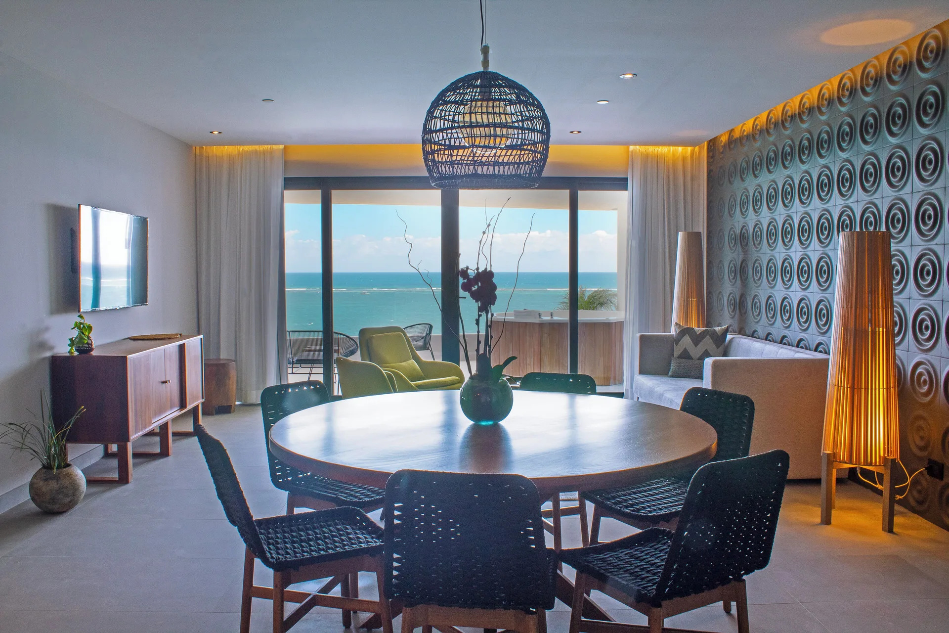 Ocean-view living and dining area in a guest room at The Fives Oceanfront Riviera Maya.