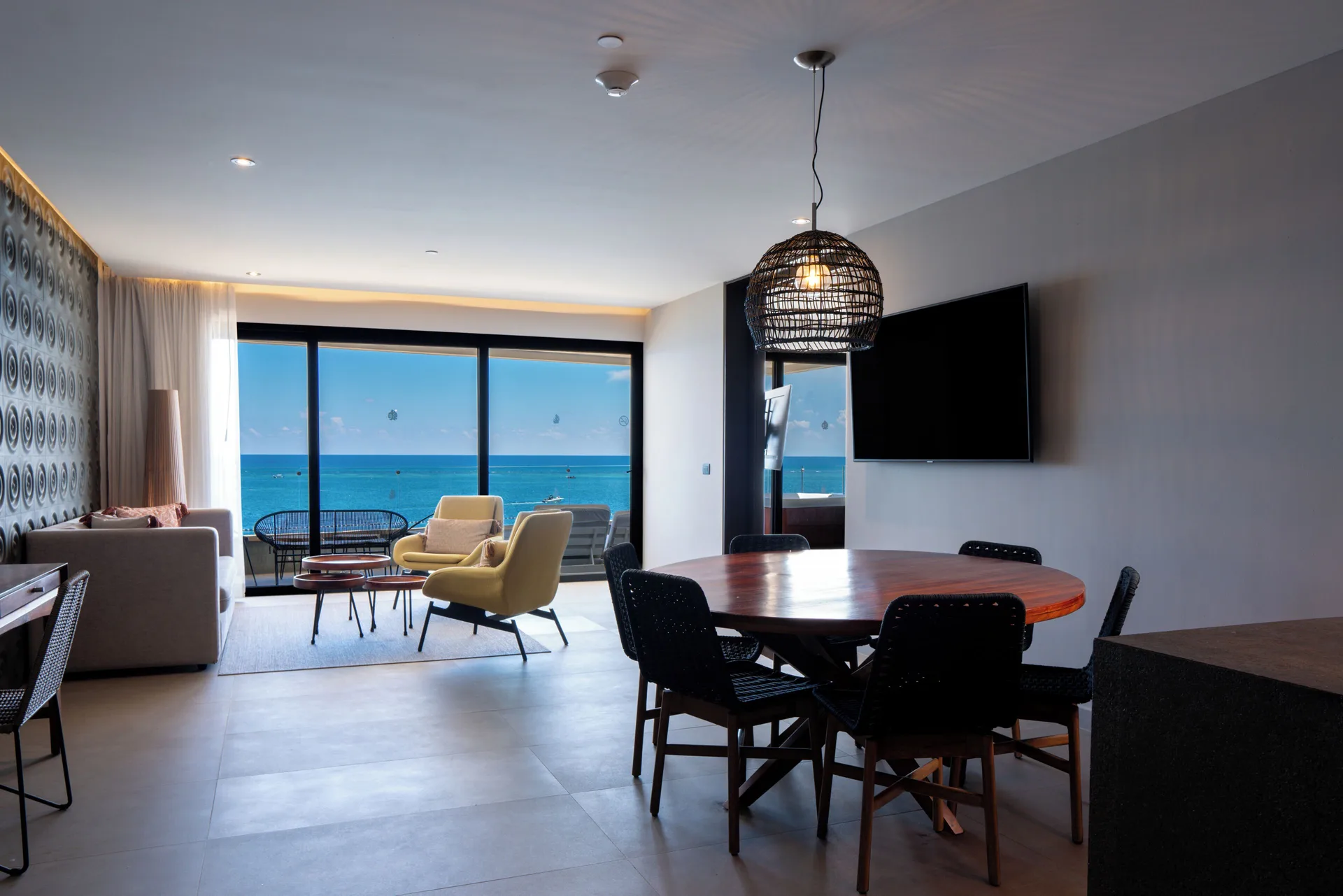 Oceanfront living and dining area with balcony at The Fives Oceanfront Riviera Maya.