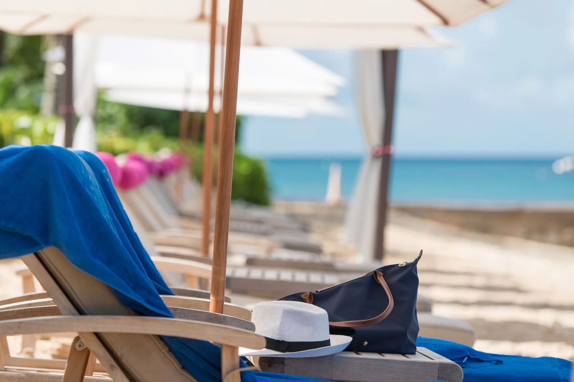 Beach lounger with towel, hat and bag facing the sea at The House.