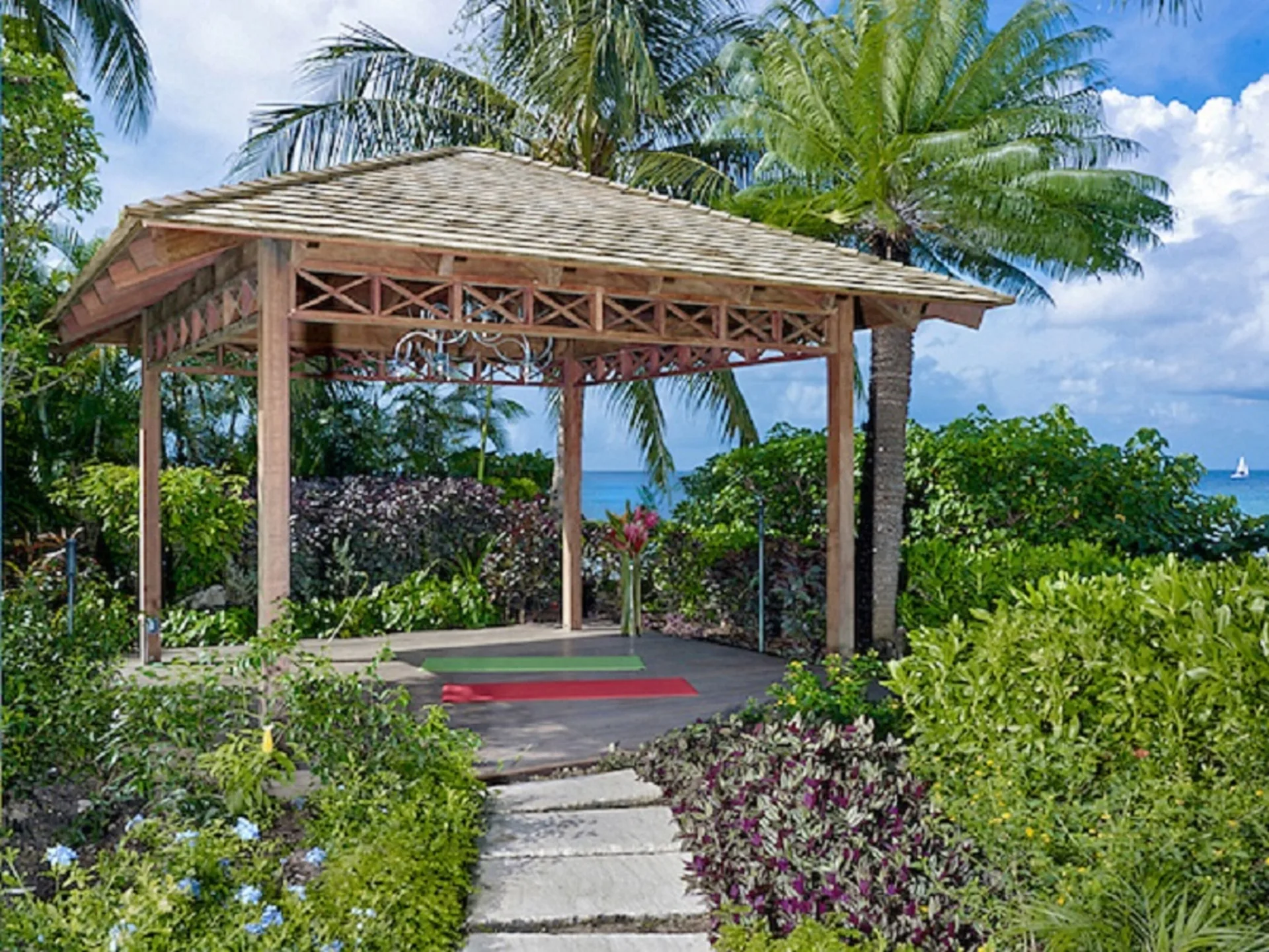 Garden pavilion with mats, tropical plants and ocean glimpses at The House.