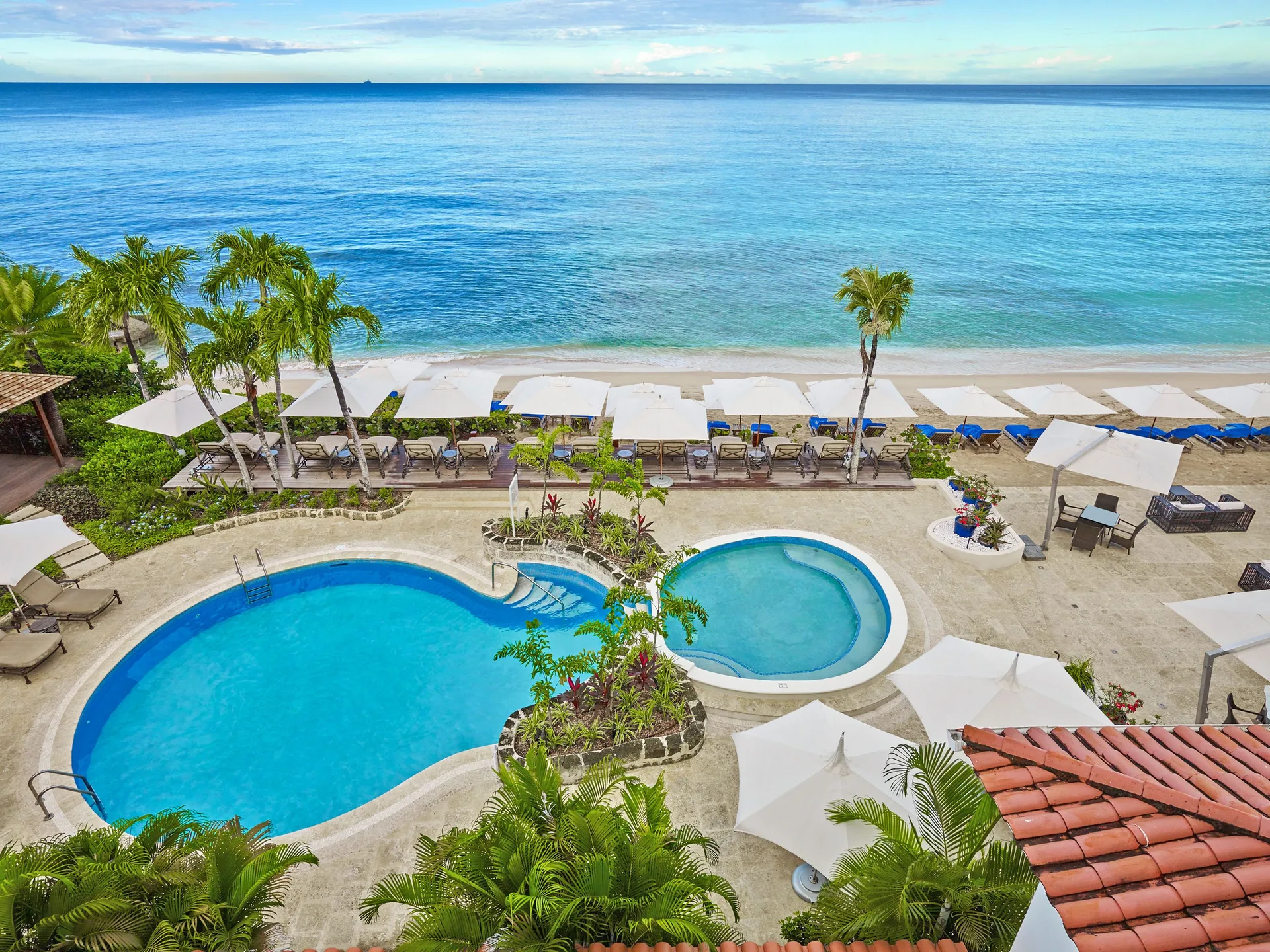 Oceanfront pool deck, beach loungers, umbrellas and palms at The House.