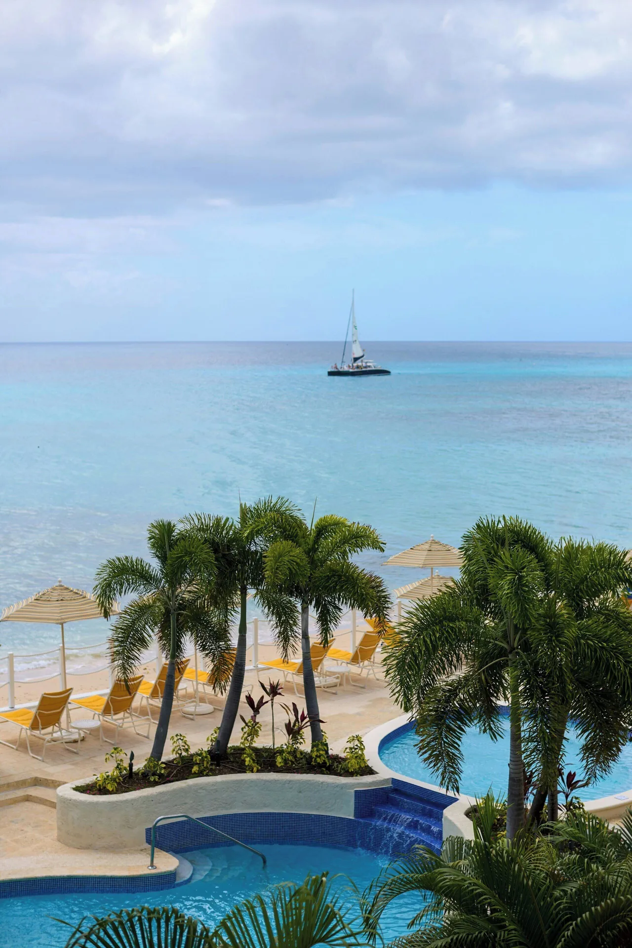 Ocean View 1 Bedroom Suite view of palms, pool, beach and sailboat at The House.