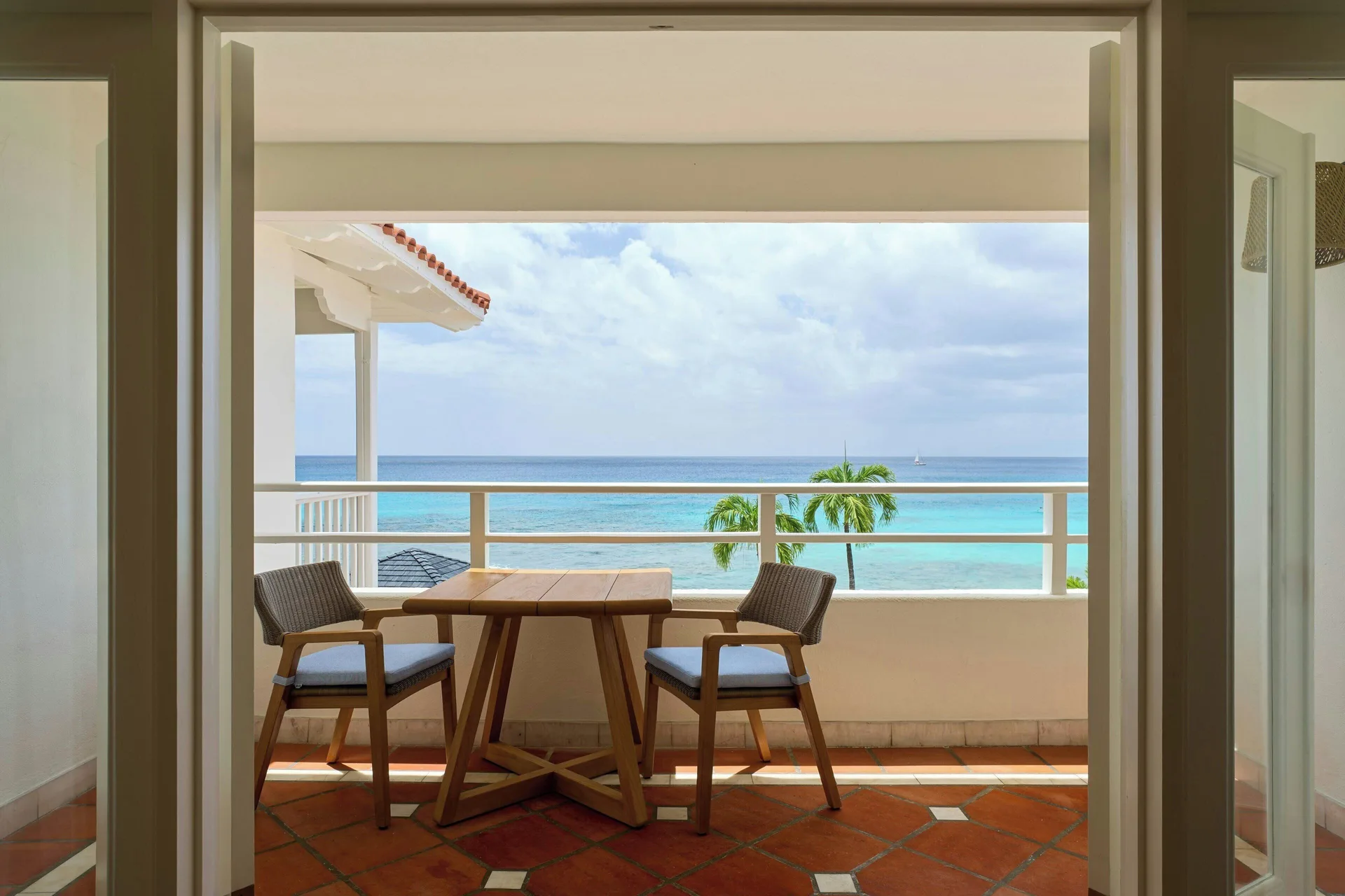 Ocean View 1 Bedroom Suite balcony with table, chairs and sea view at The House.