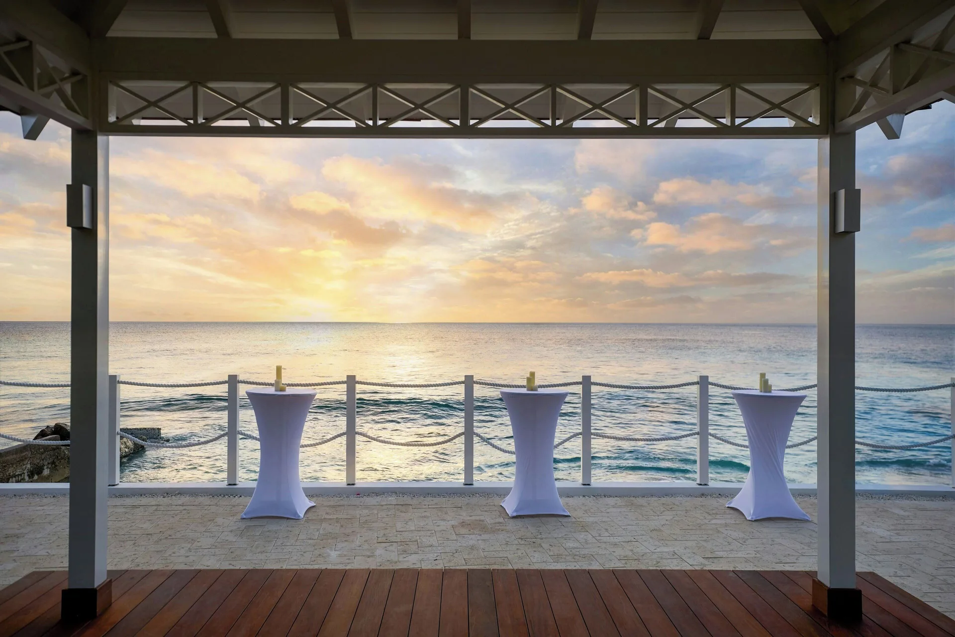 Oceanfront terrace with cocktail tables at sunset at The House.