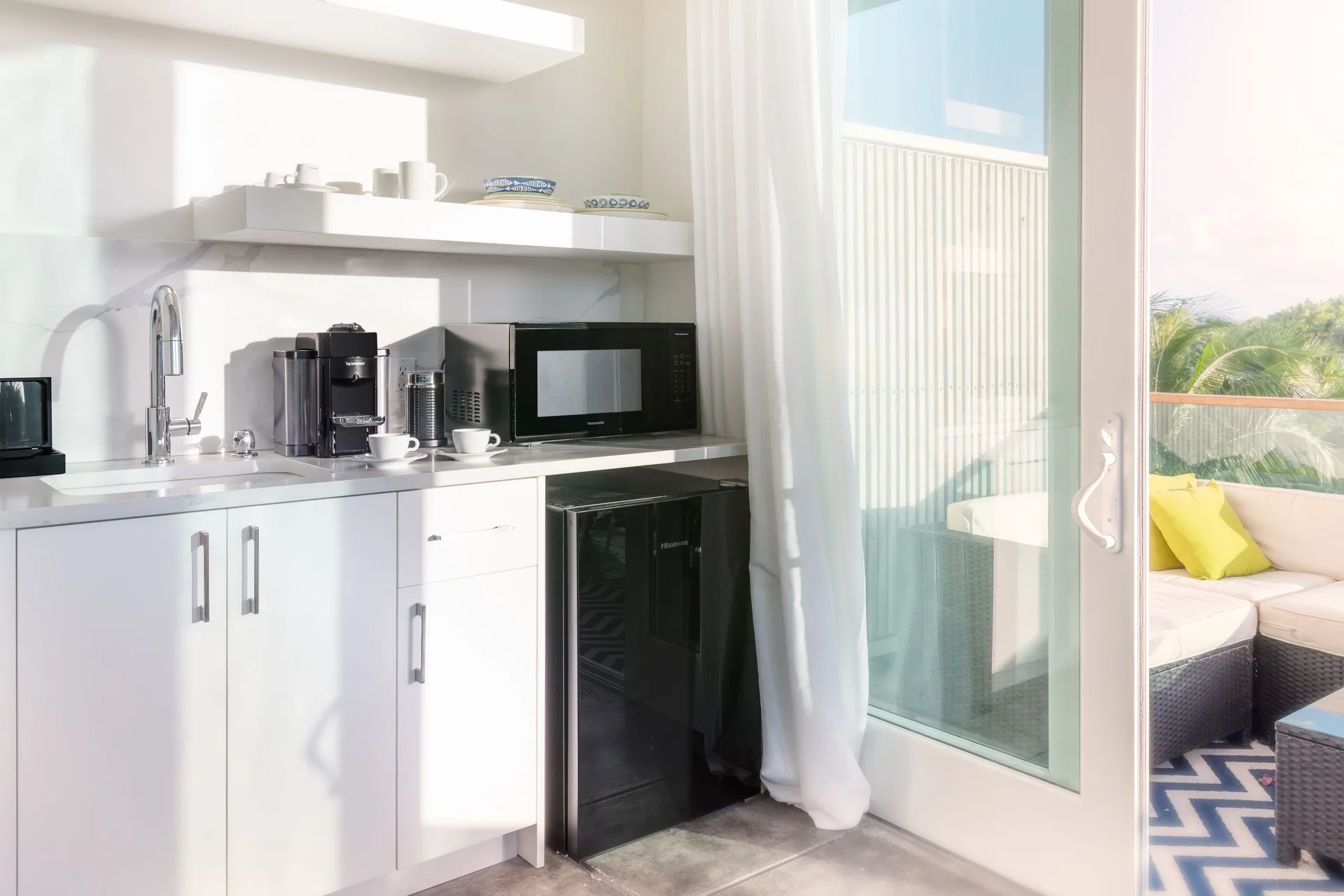 Deluxe Room kitchenette and balcony seating at The Oasis at Grace Bay.