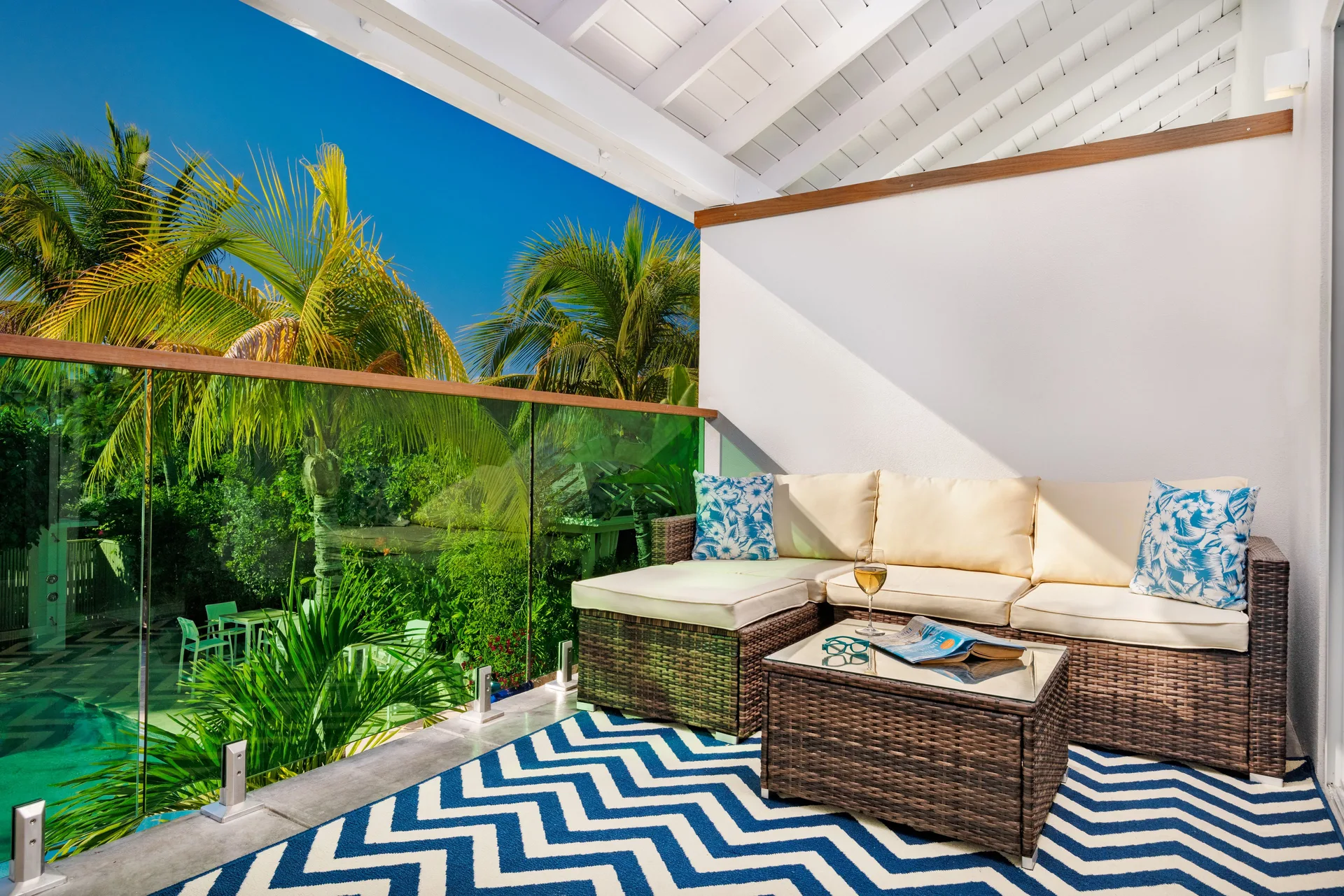 Luxury Room balcony seating with palm views at The Oasis at Grace Bay.