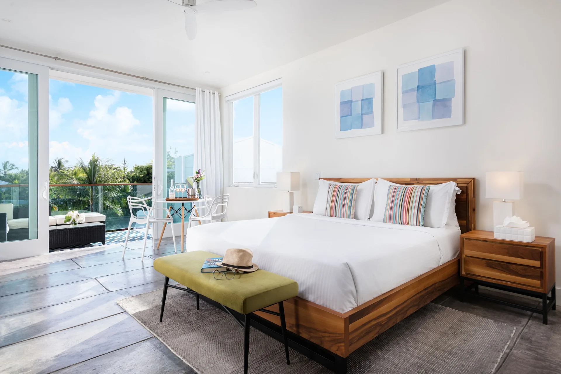 Luxury Room king bed with balcony doors and dining nook at The Oasis at Grace Bay.