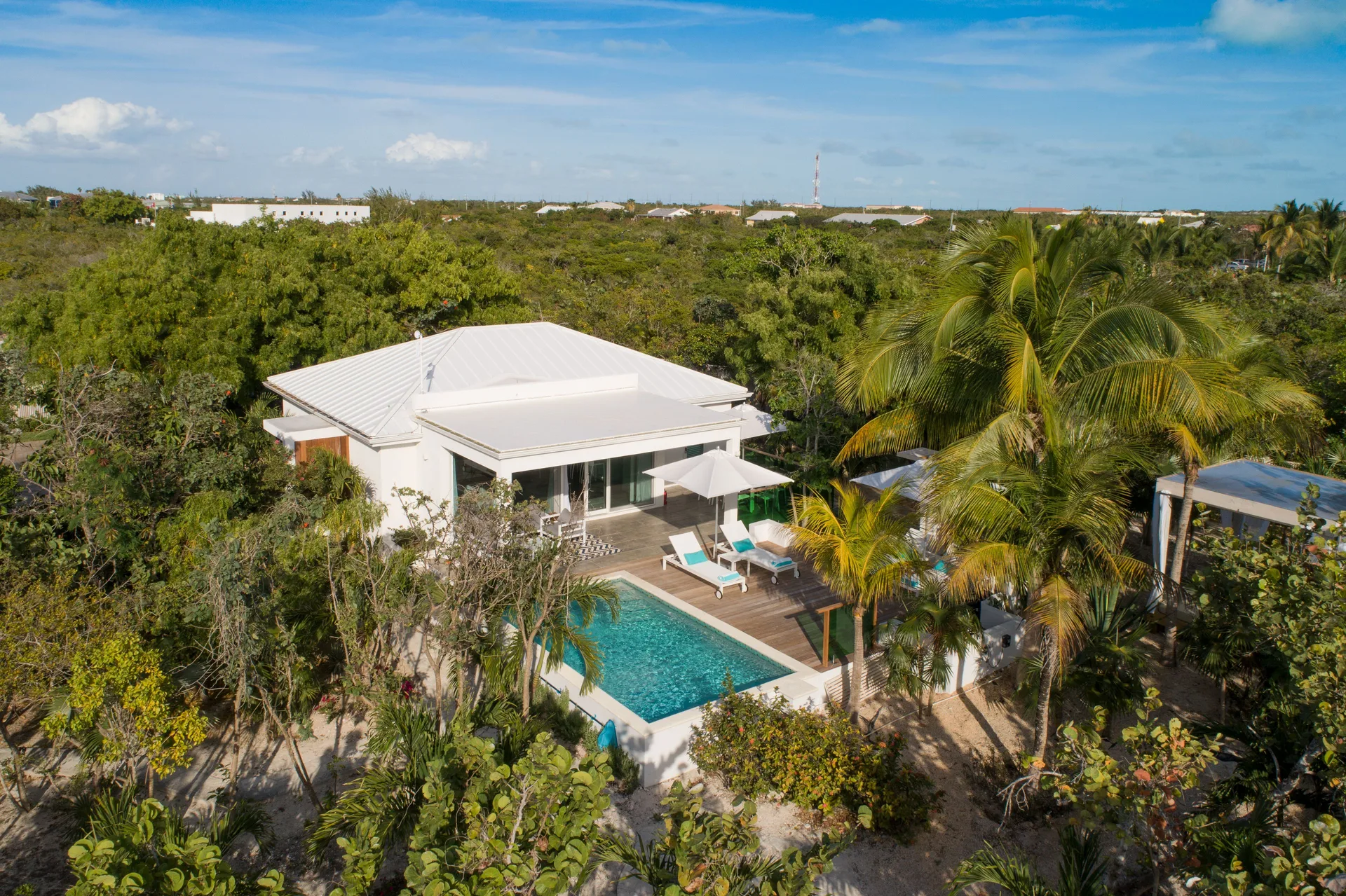 Aerial view of a private villa pool and patio surrounded by palms at The Oasis at Grace Bay.