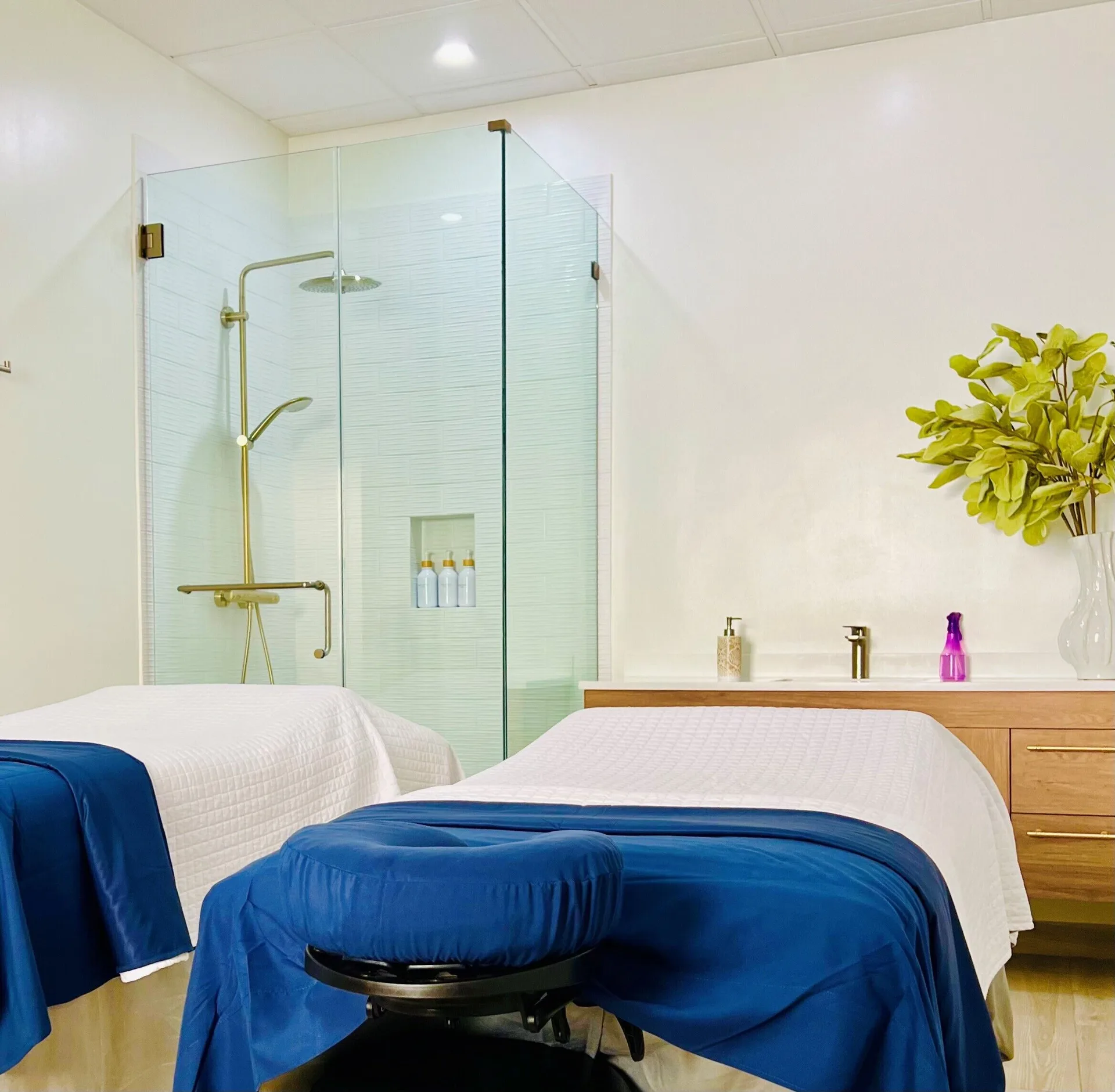 Spa treatment beds and glass shower in a treatment room at The Sands at Grace Bay.