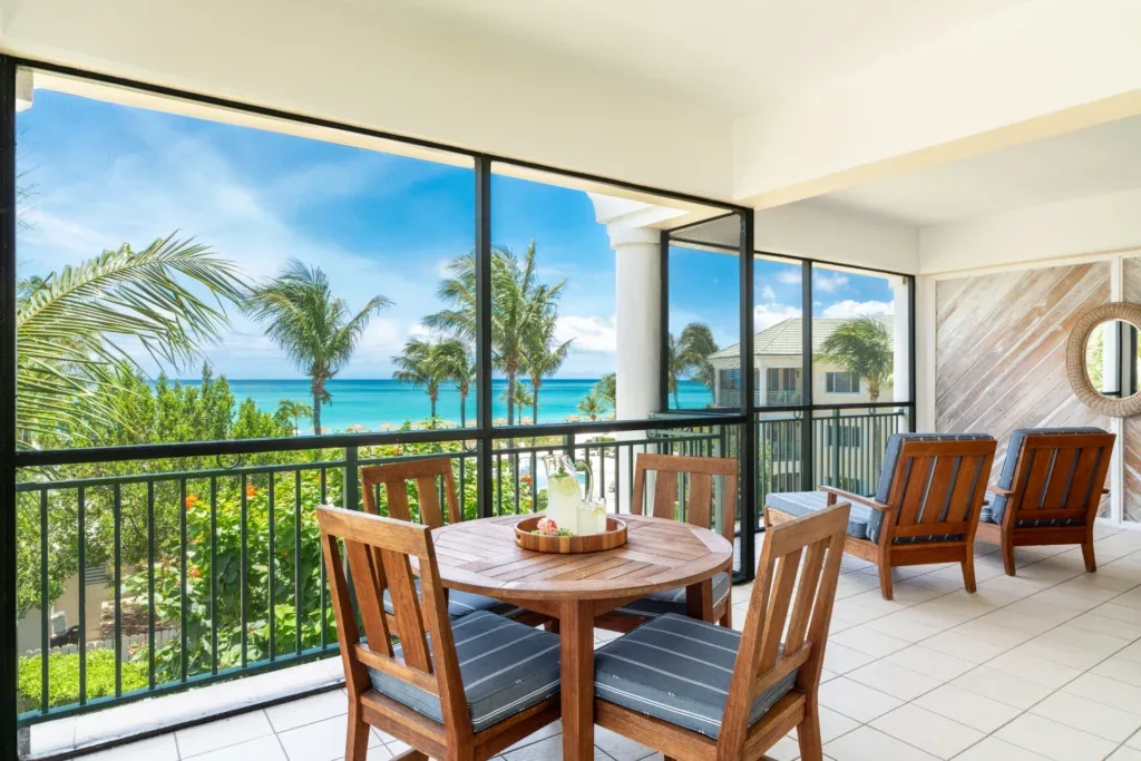Oceanfront balcony dining area with turquoise water views at The Sands at Grace Bay.