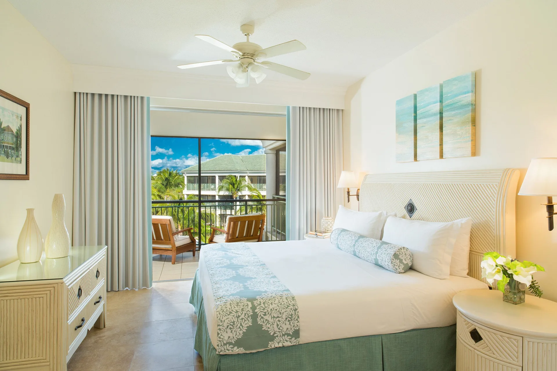 Junior Suite Garden View bedroom with king bed and balcony at The Sands at Grace Bay.