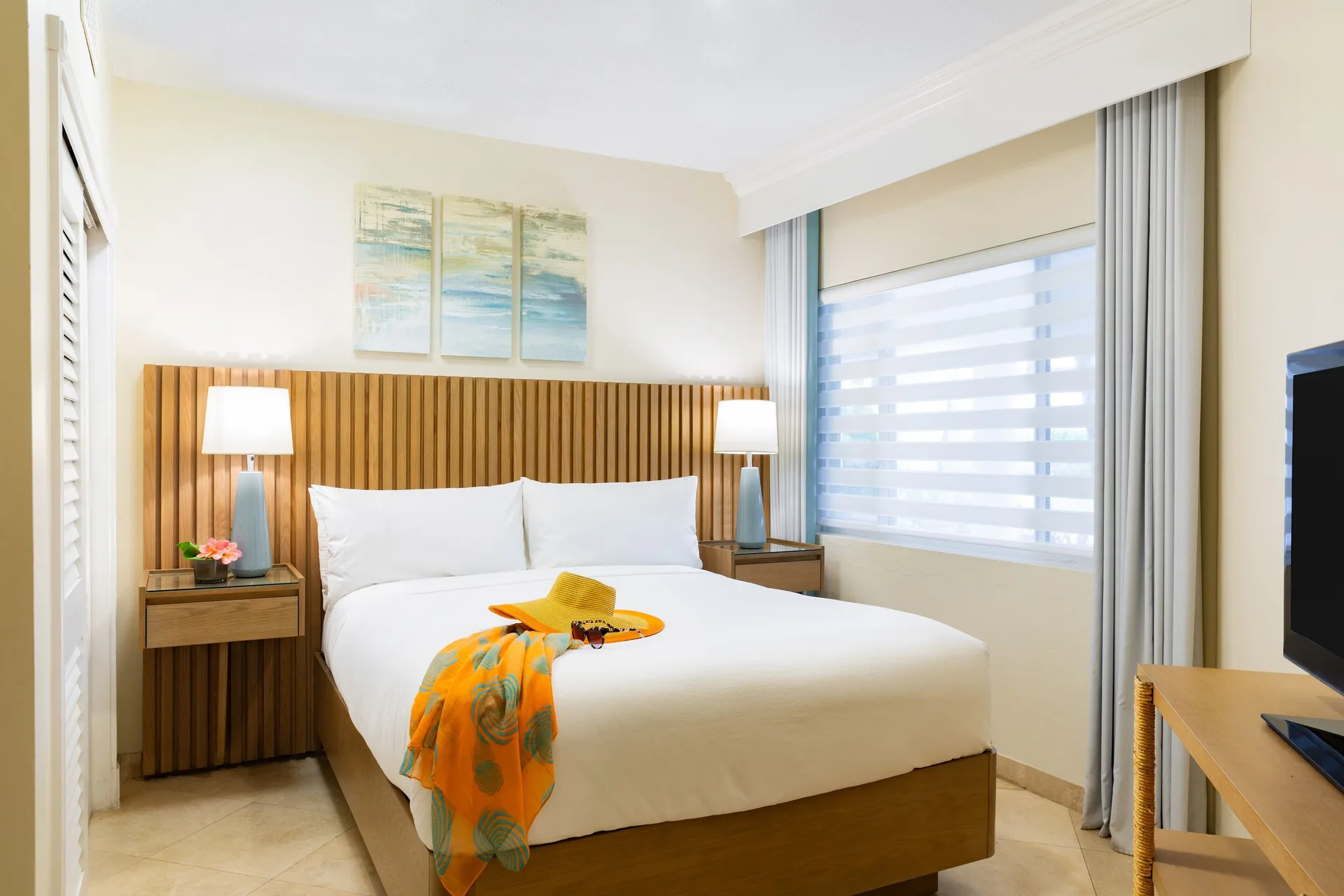 One-bedroom garden view suite bedroom with king bed and TV at The Sands at Grace Bay.
