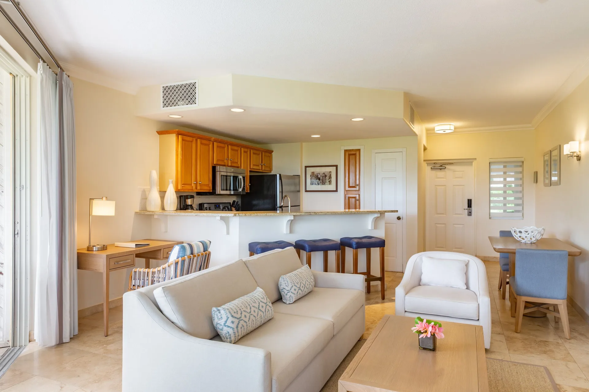 One-bedroom garden view suite living area with kitchen and dining table at The Sands at Grace Bay.