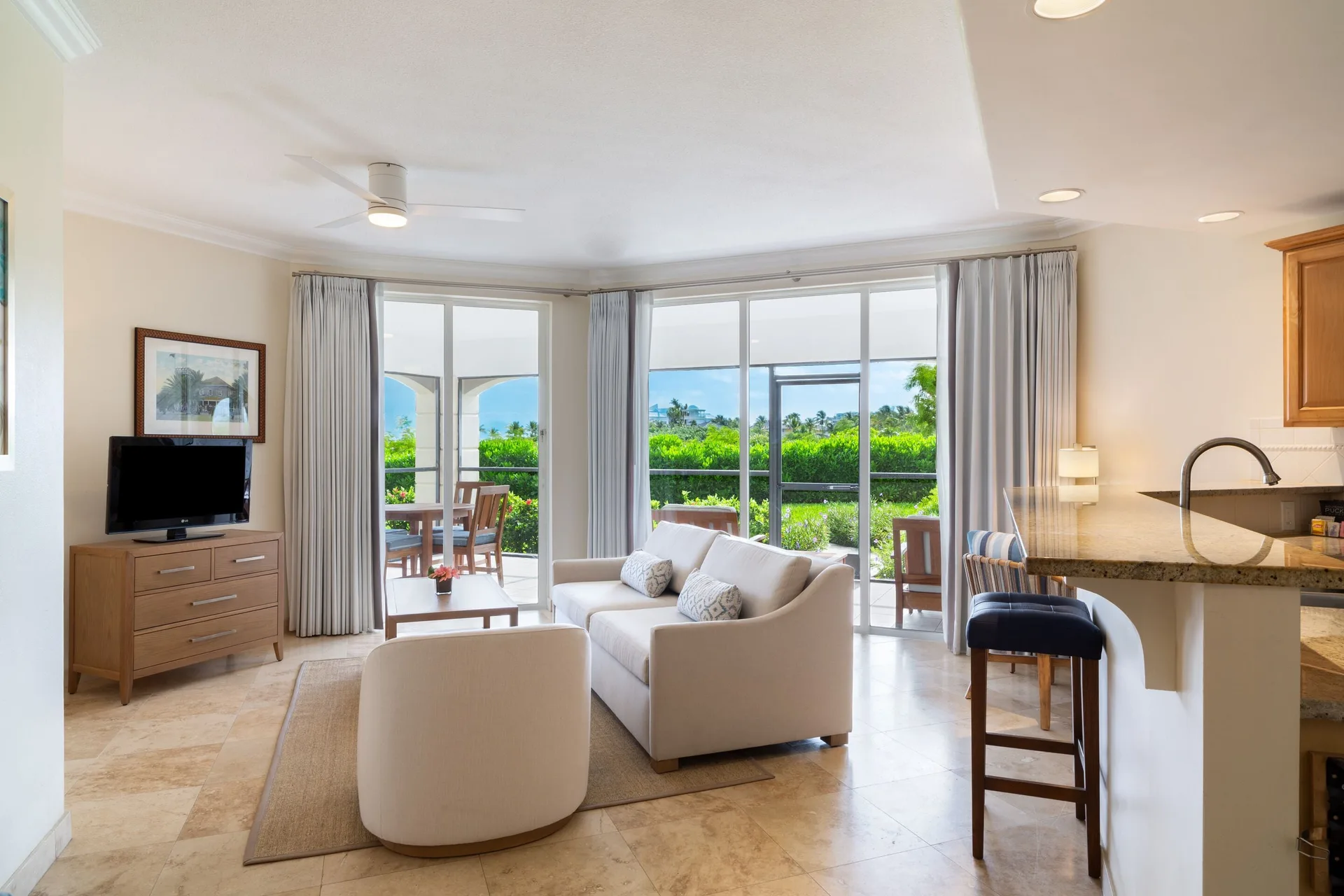 One-bedroom garden view suite living room with sofa and patio doors at The Sands at Grace Bay.
