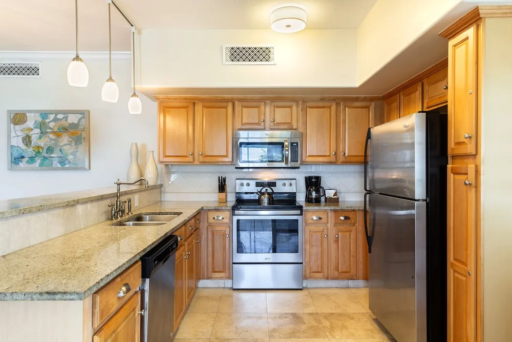 Full kitchen with wood cabinetry in a suite at The Sands at Grace Bay.