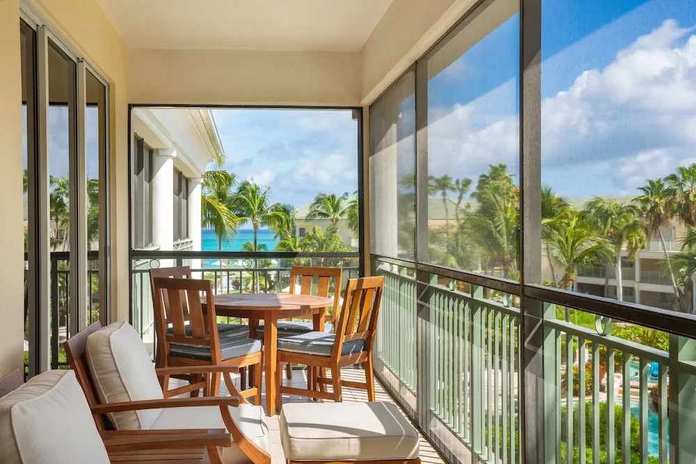Screened ocean view balcony with seating at The Sands at Grace Bay.