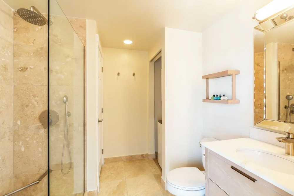 Bathroom with glass shower and vanity in a two-bedroom ocean view suite at The Sands at Grace Bay.