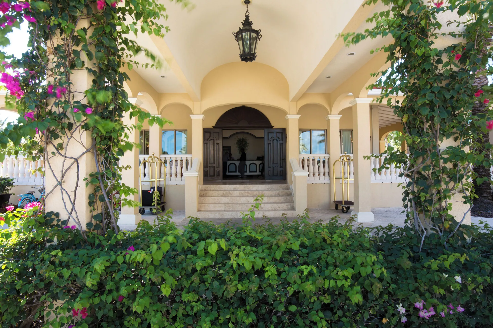 Arched lobby entrance with vines and luggage carts at The Somerset on Grace Bay.