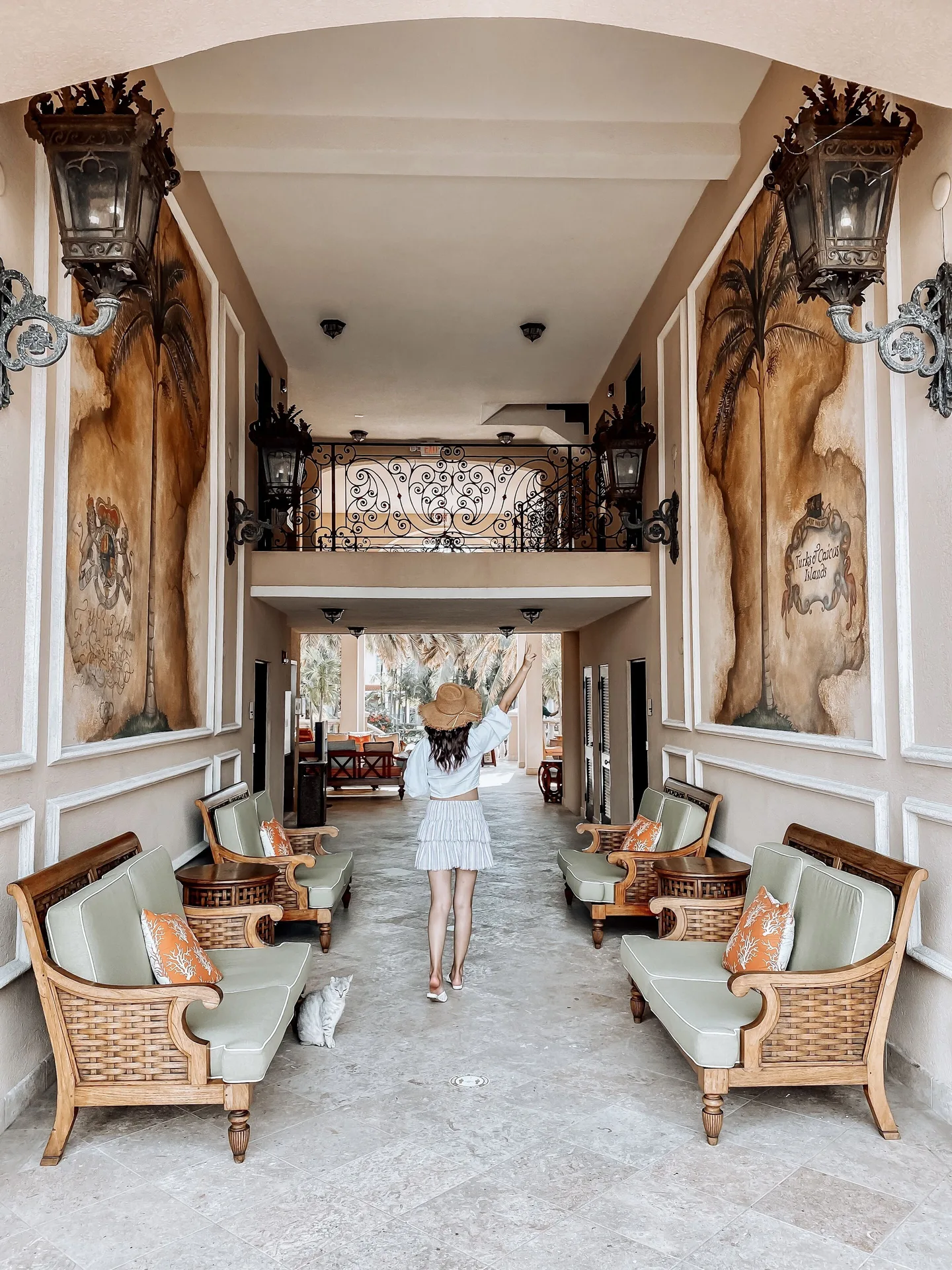 Covered resort corridor with wicker seating and wall murals at The Somerset on Grace Bay.