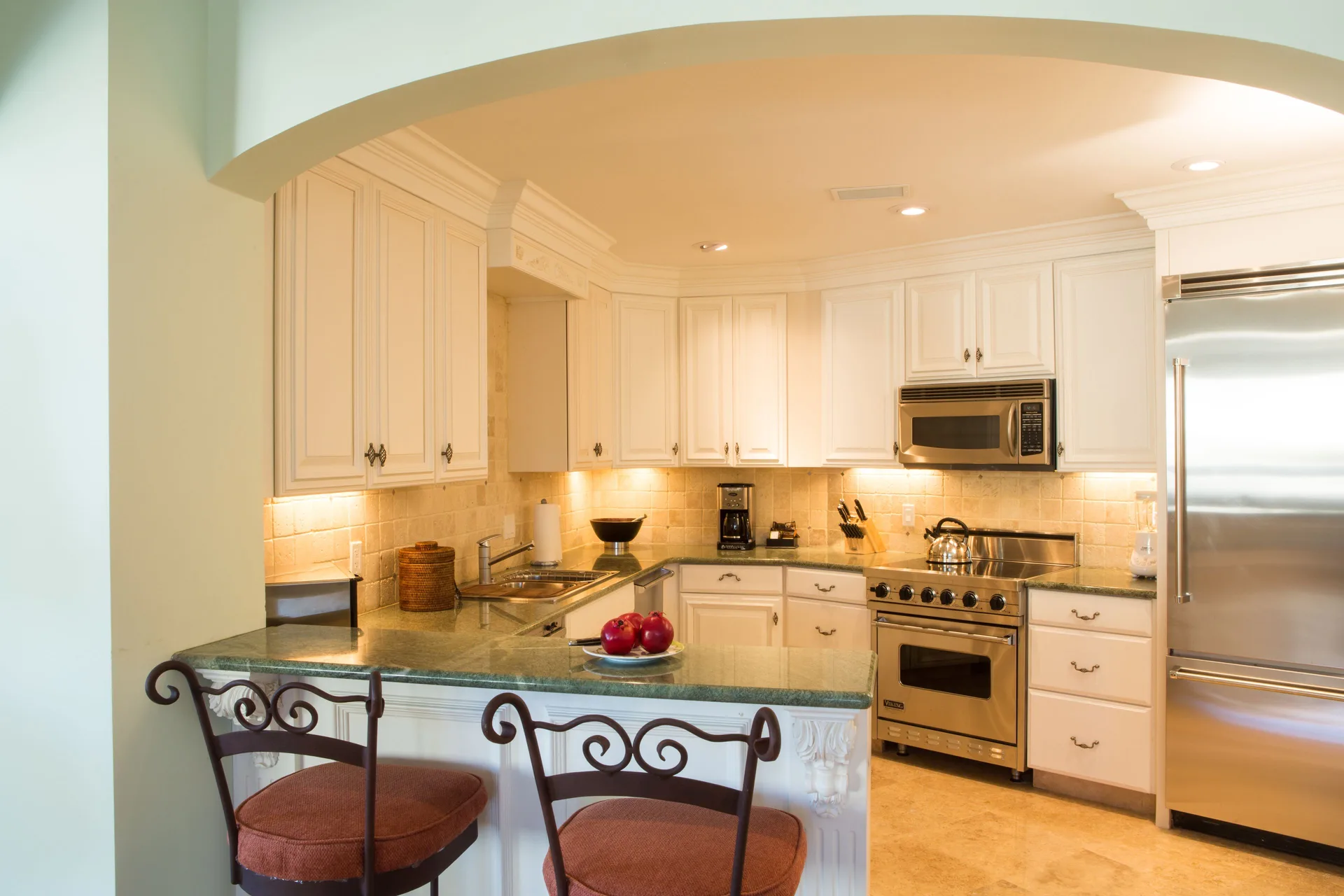 Guest suite kitchen with white cabinets and breakfast bar at The Somerset on Grace Bay.
