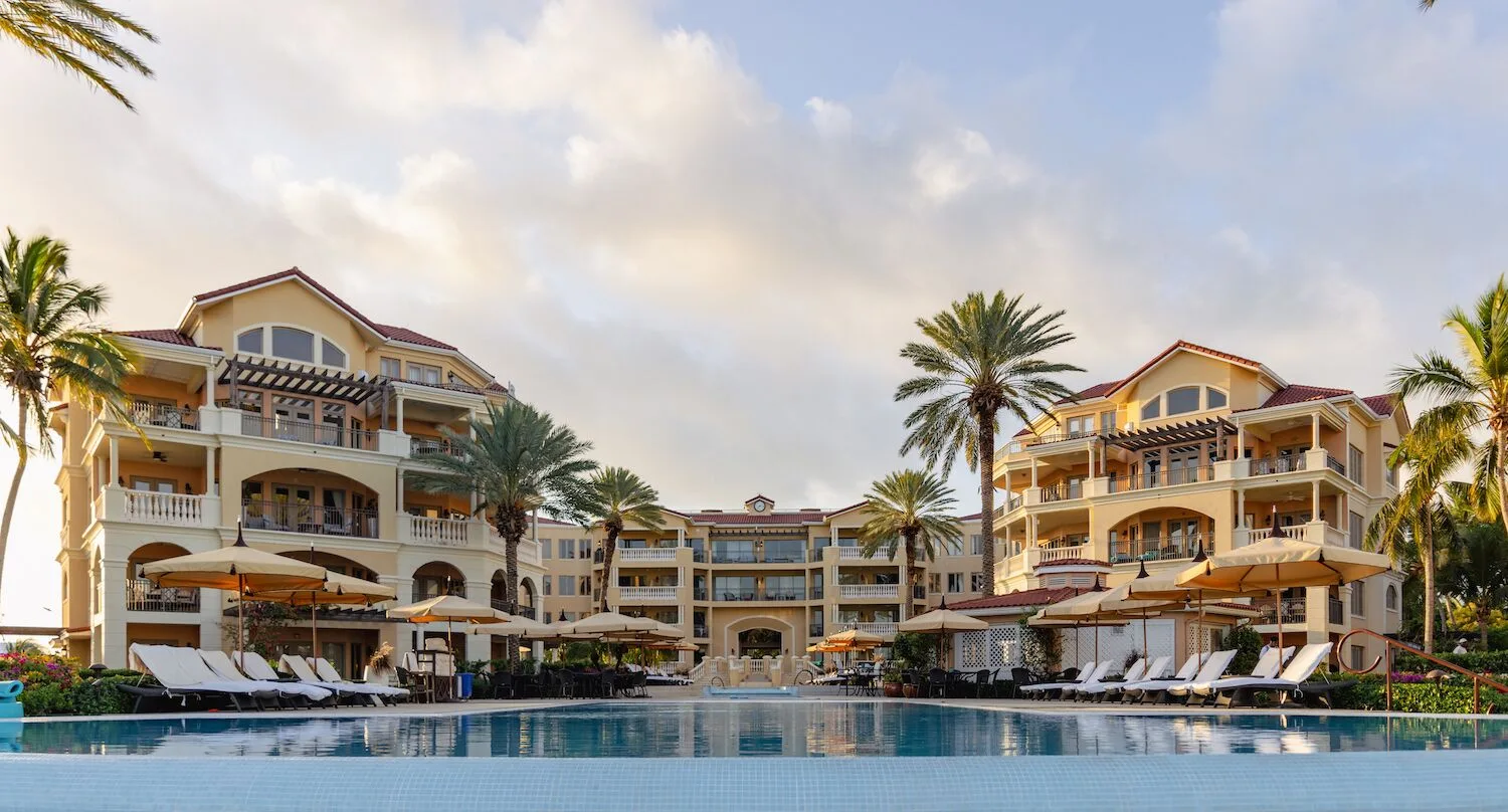 Pool, loungers, palms, and resort buildings at The Somerset on Grace Bay.