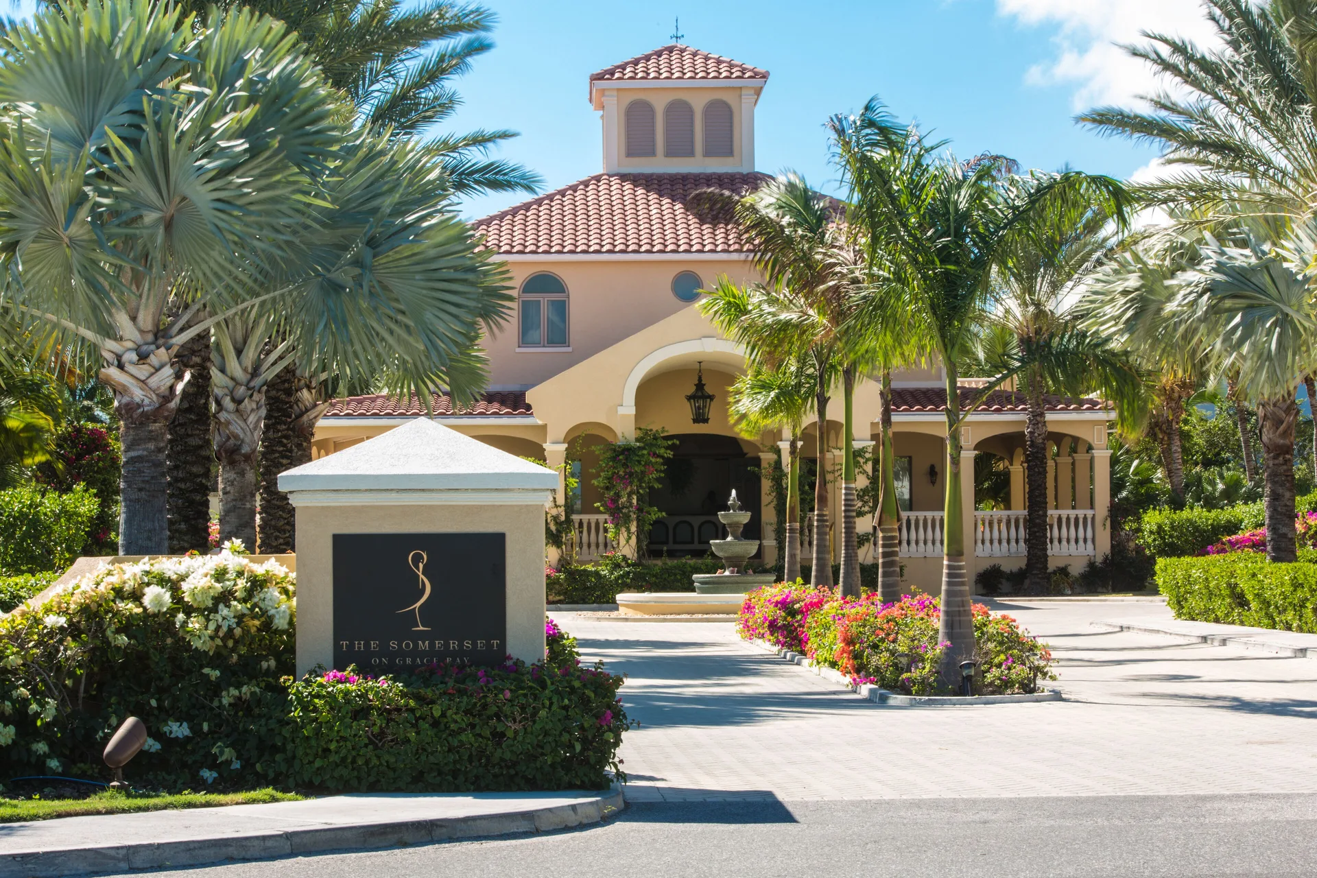 Palm-lined entrance sign and resort building at The Somerset on Grace Bay.