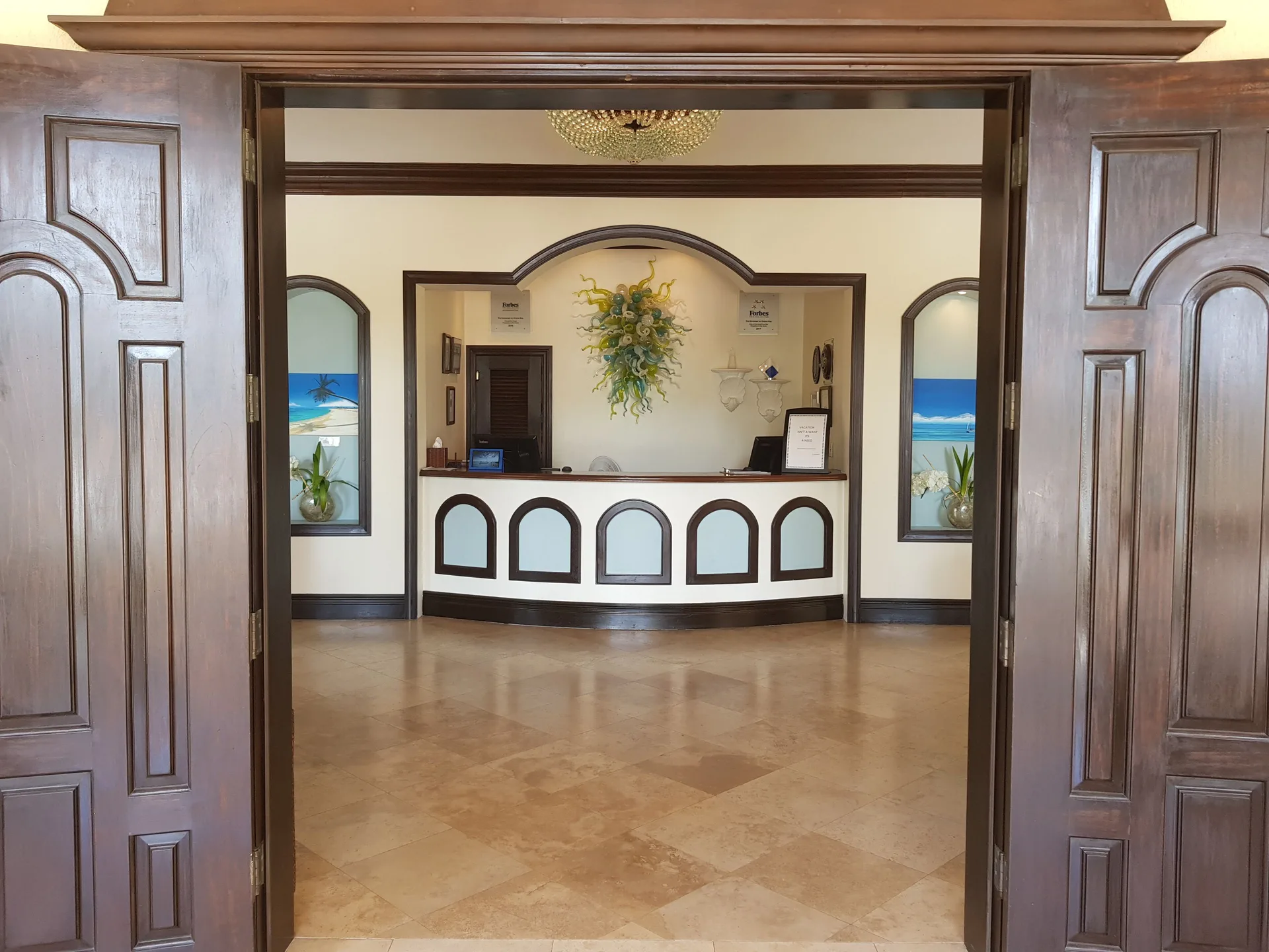 Reception desk viewed through wooden doors at The Somerset on Grace Bay.