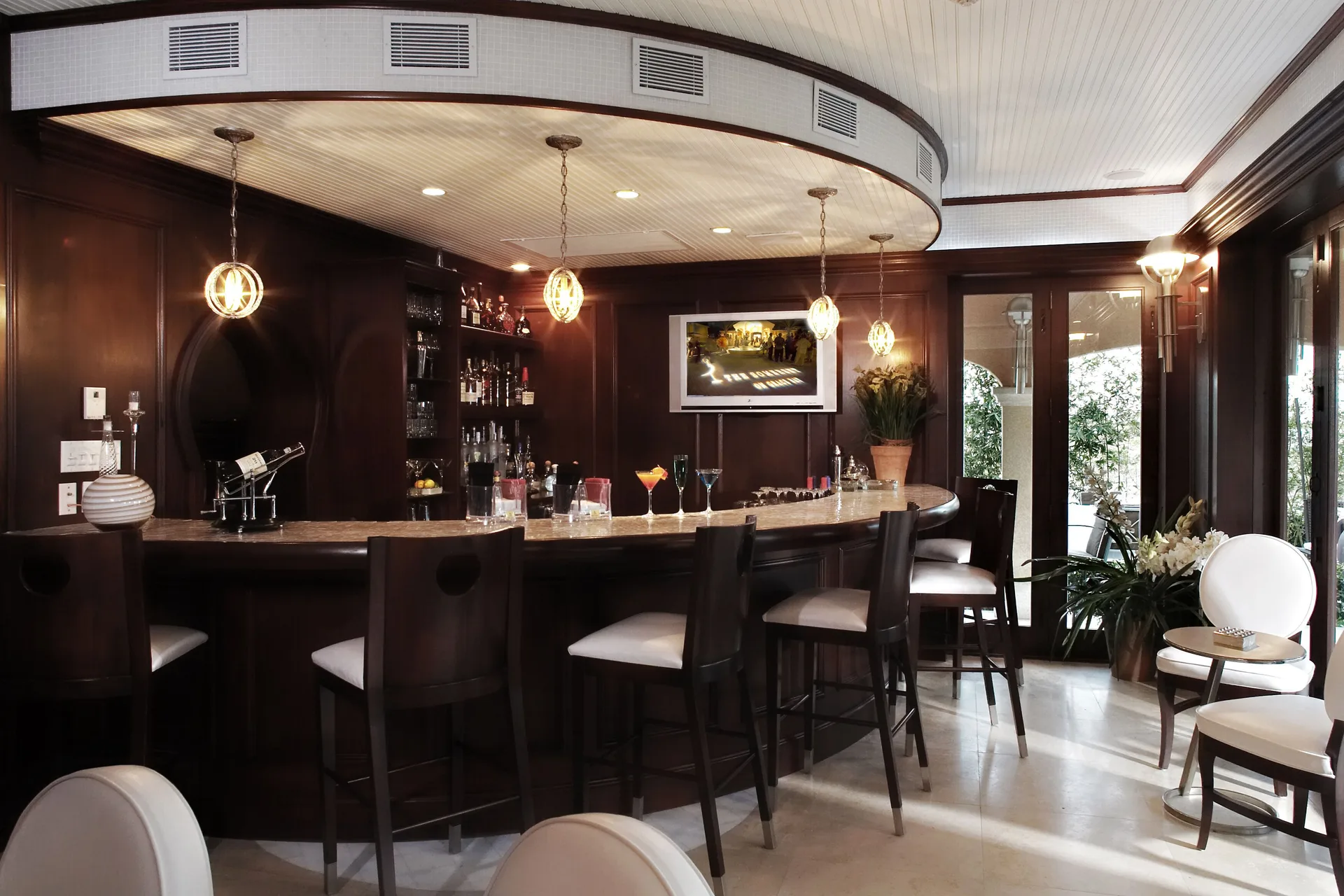 Dark wood bar with stools and pendant lights at The Somerset on Grace Bay.