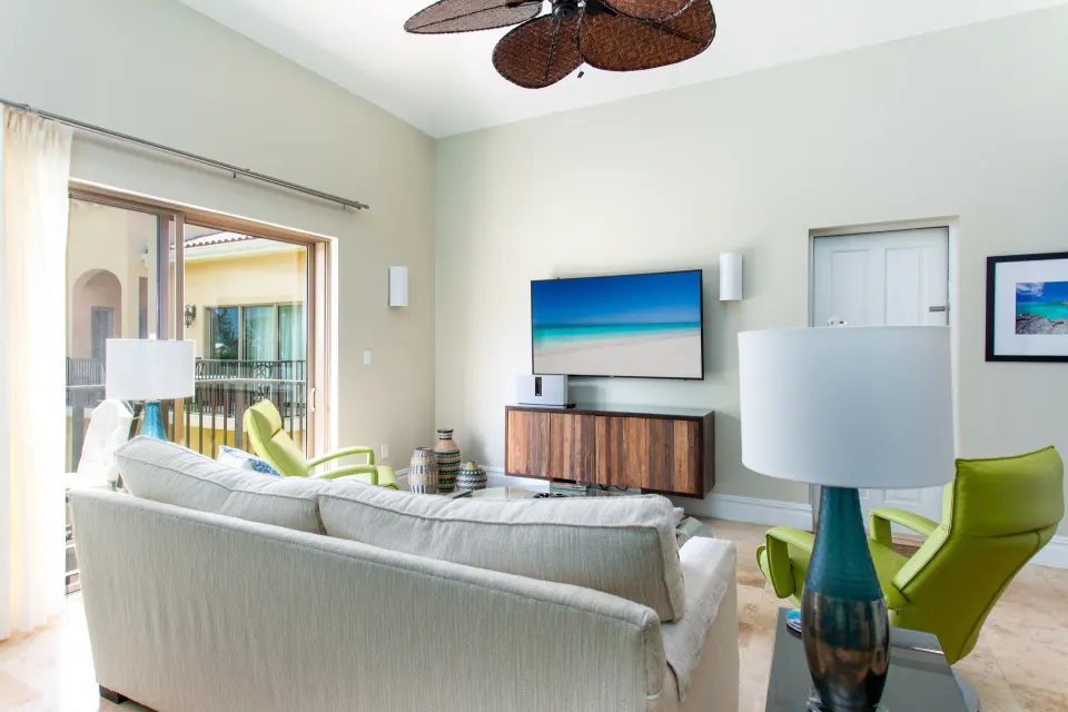 1 Bedroom Residence living room with TV and balcony at The Somerset on Grace Bay.