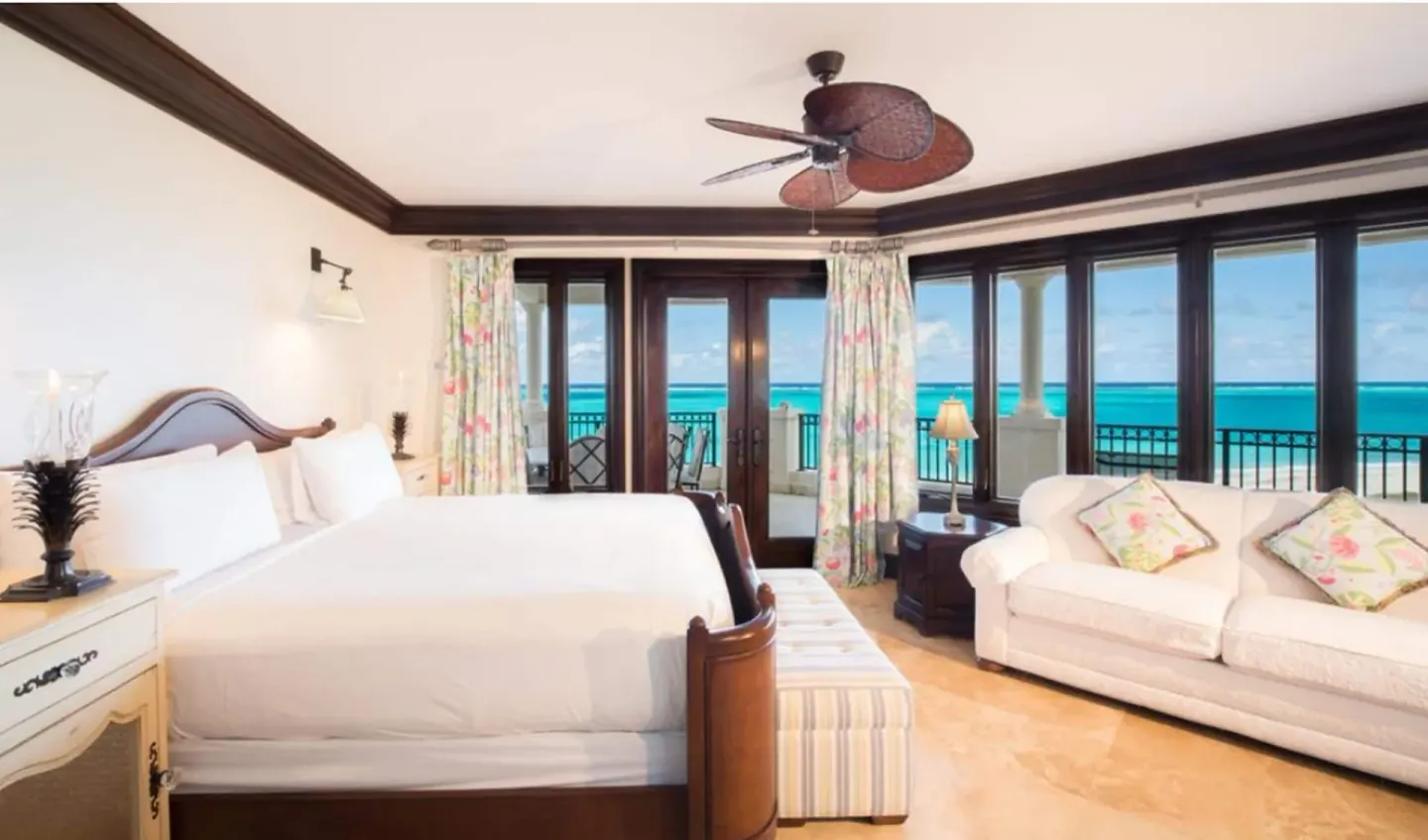 Oceanfront bedroom with a white bed and balcony view at The Somerset on Grace Bay.