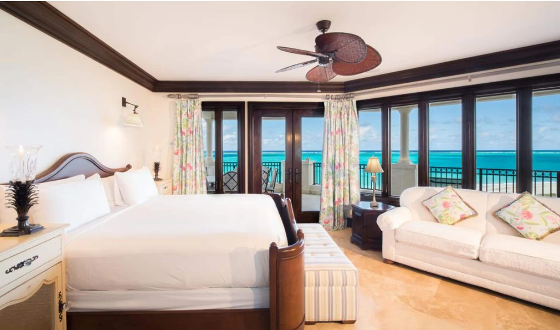 Oceanfront bedroom with a white bed and balcony view at The Somerset on Grace Bay.