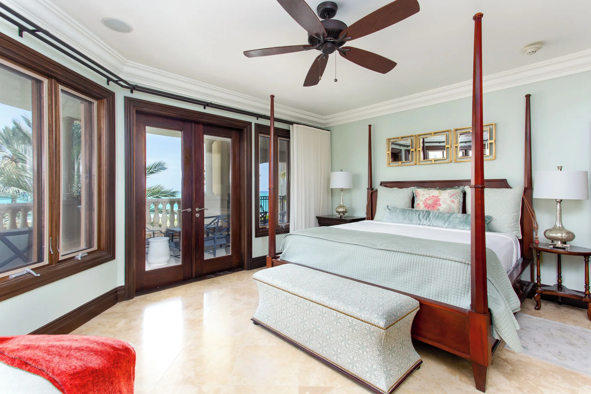 Guest bedroom with four-poster king bed and balcony doors at The Somerset on Grace Bay.