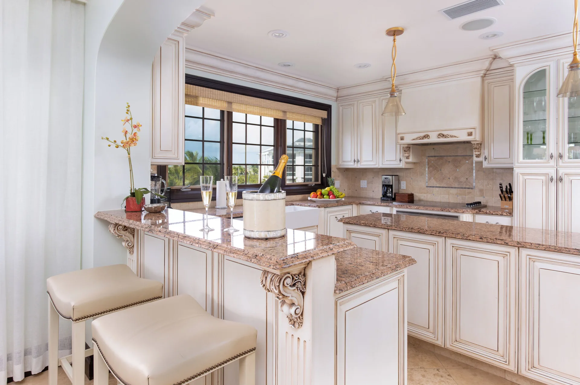Kitchen with granite counters, white cabinetry, and bar stools at The Somerset on Grace Bay.