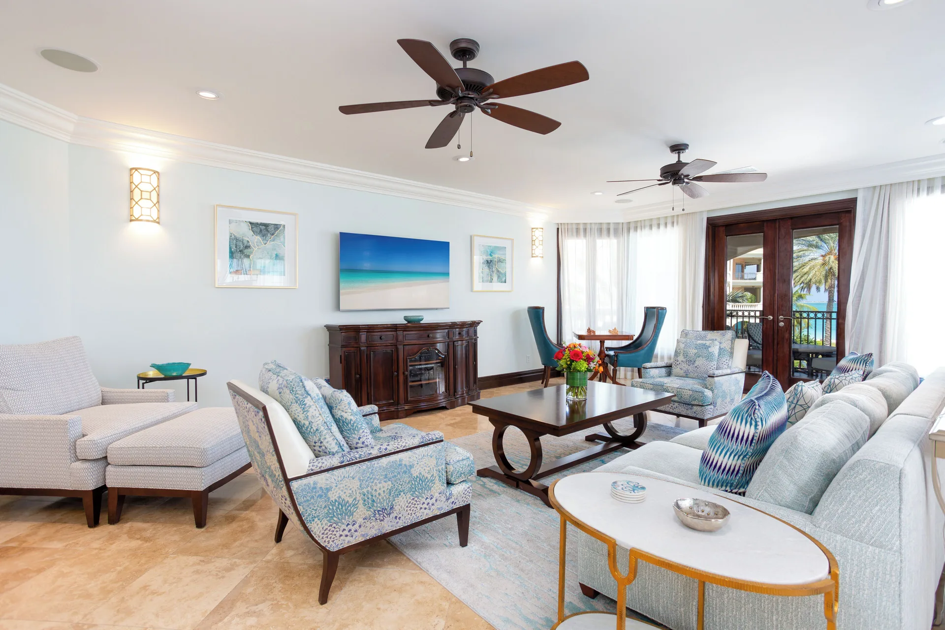 Living room with sofas, lounge chairs, and balcony doors at The Somerset on Grace Bay.