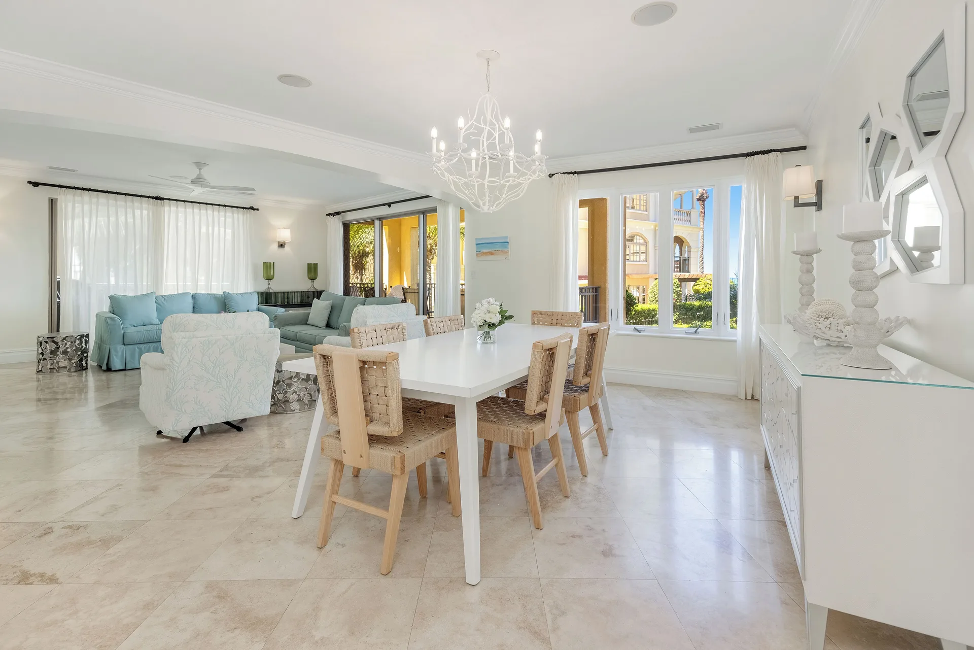 Open living and dining area in the Family Villa at The Somerset on Grace Bay with chandelier and sofas.