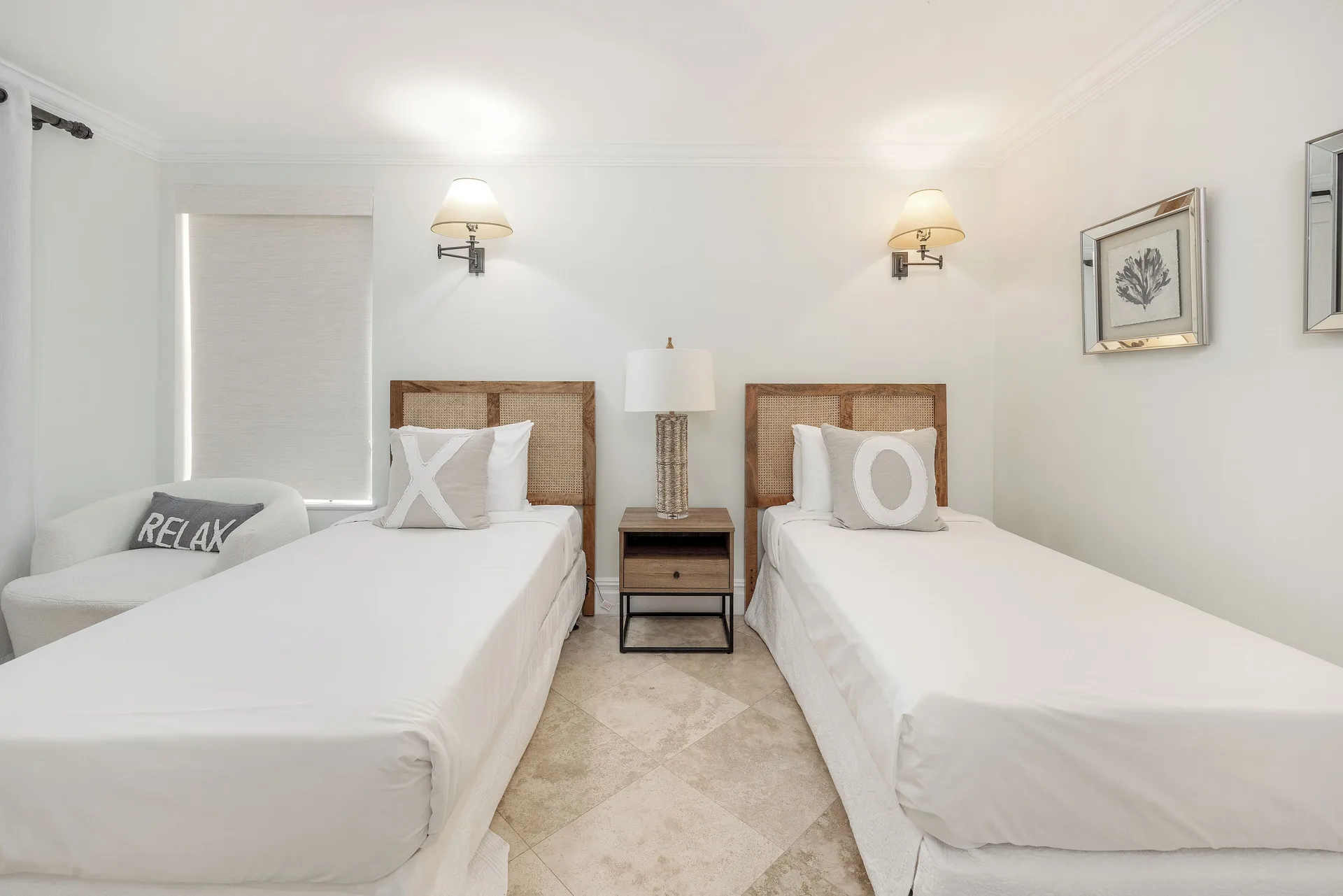 Twin bedroom in the Family Villa at The Somerset on Grace Bay with white bedding and cane headboards.