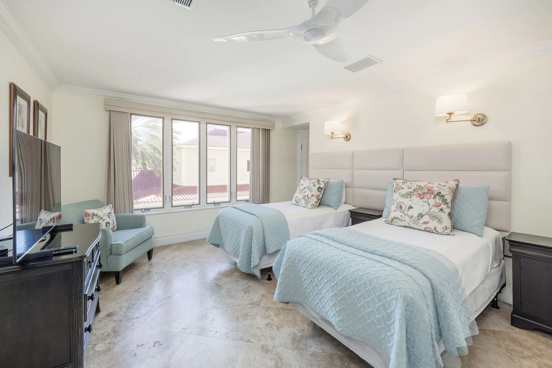 Bedroom in the Family Villa at The Somerset on Grace Bay with two beds, blue coverlets, TV, and windows.