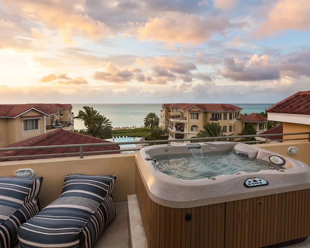 Penthouse terrace hot tub with ocean and sunset views at The Somerset on Grace Bay.