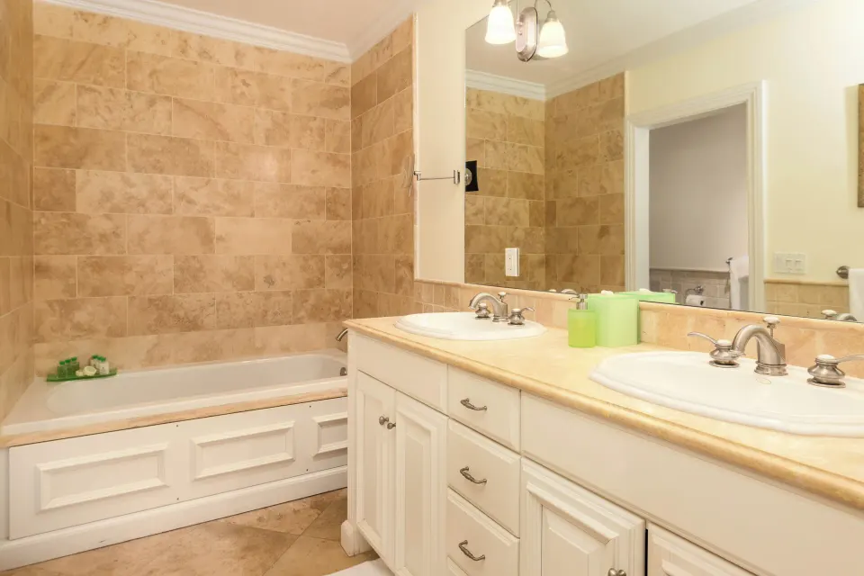 Villa ocean view bathroom with double vanity and tiled bathtub at The Somerset on Grace Bay.