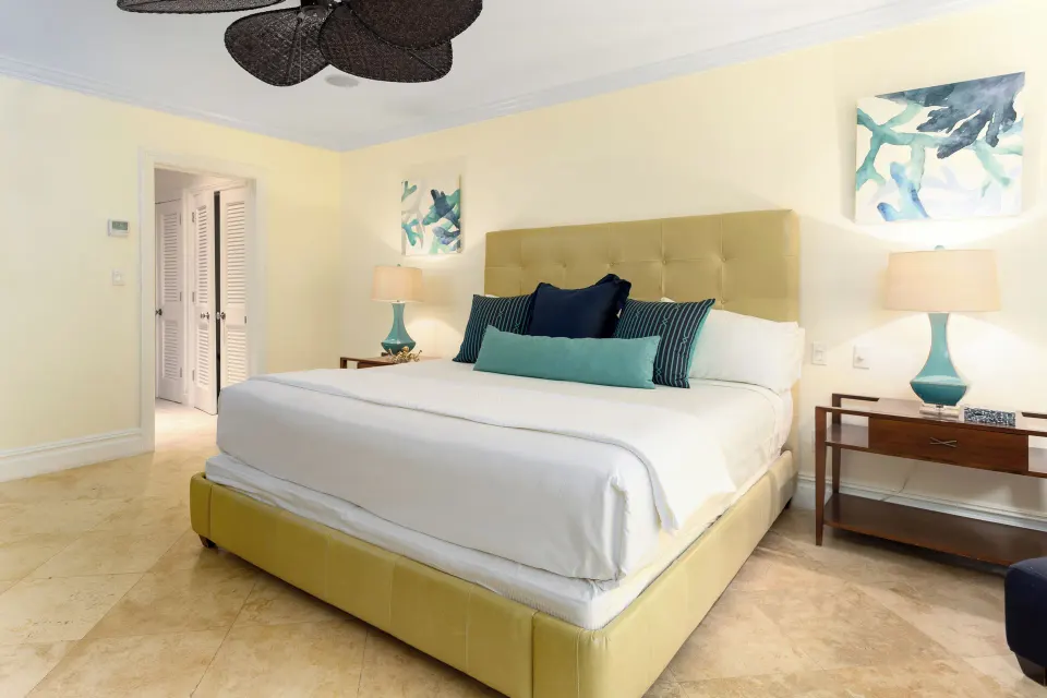 Villa ocean view bedroom with a king bed and turquoise accents at The Somerset on Grace Bay.